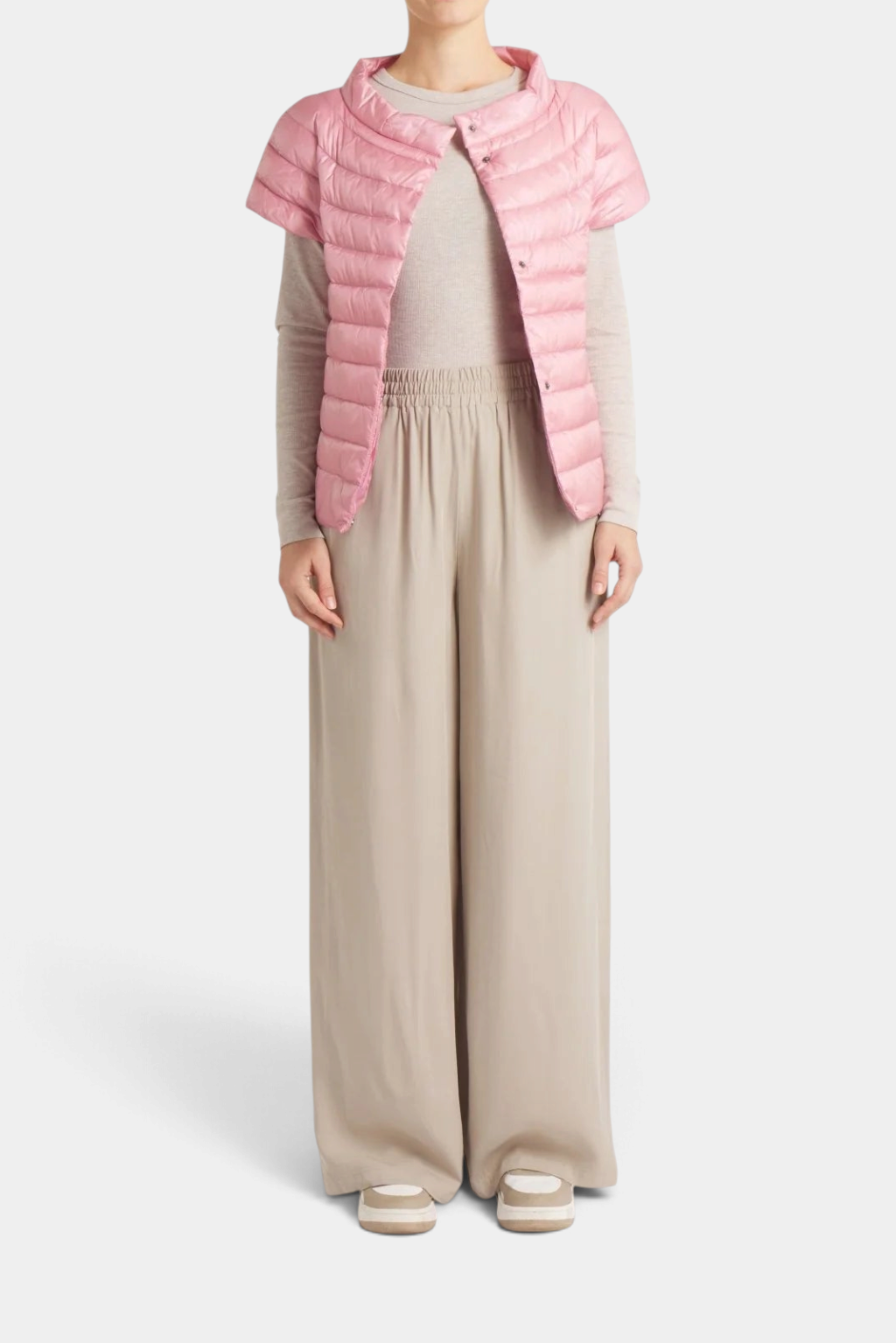 Model wearing The Copper Shed pink quilted 1/4 sleeve down vest with hidden press buttons over a beige outfit