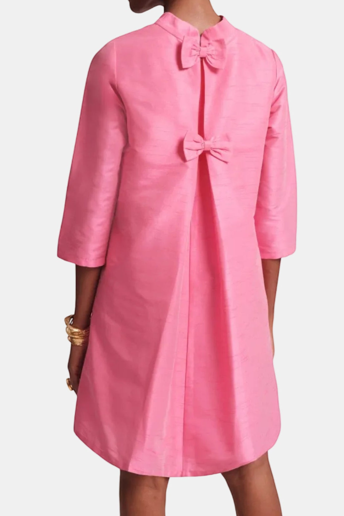 The Copper Shed pink silk mini dress with mock neckline, 3/4 sleeves, and two back bows.
