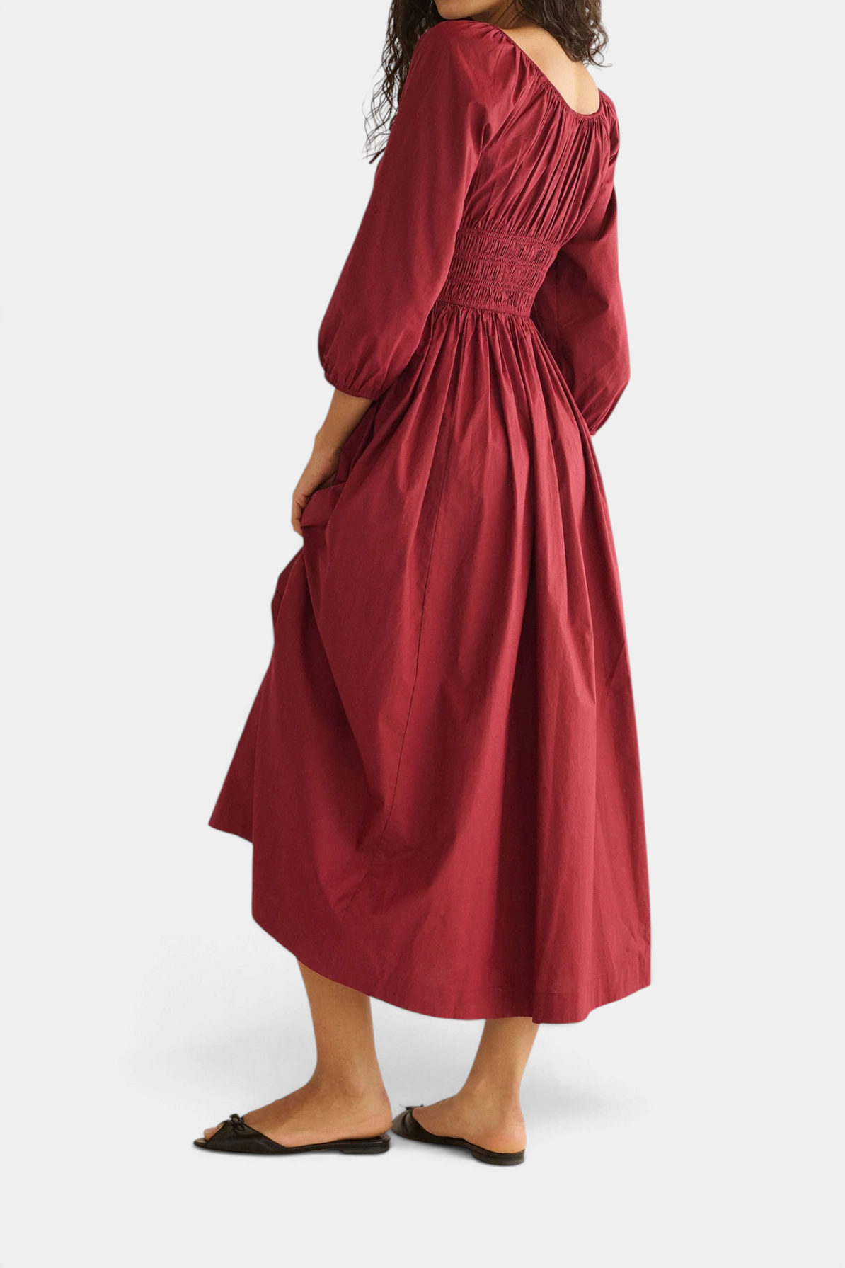 The Copper Shed Quintessa midi dress in deep red organic cotton poplin with smocked bodice and bracelet sleeves.