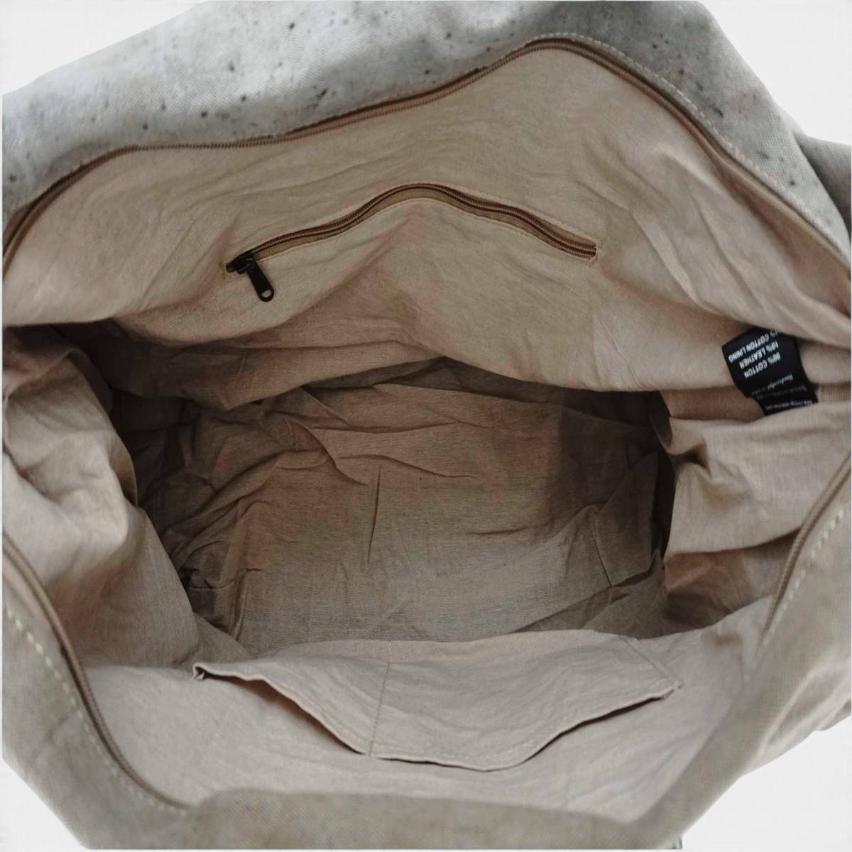 Interior view of The Copper Shed recycled military tent weekender duffle bag showing beige lining and pockets