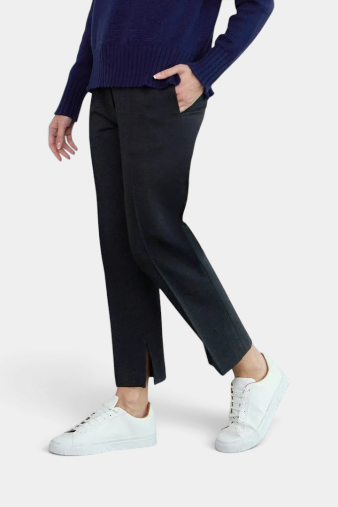 The Copper Shed Sandy tapered black ponte pants featuring a front pintuck and side slit hem worn with white sneakers.