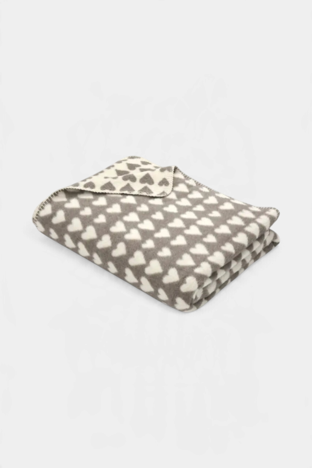 The Copper Shed SAVONA velour throw blanket in grey and cream with a repeating heart pattern and decorative stitching.