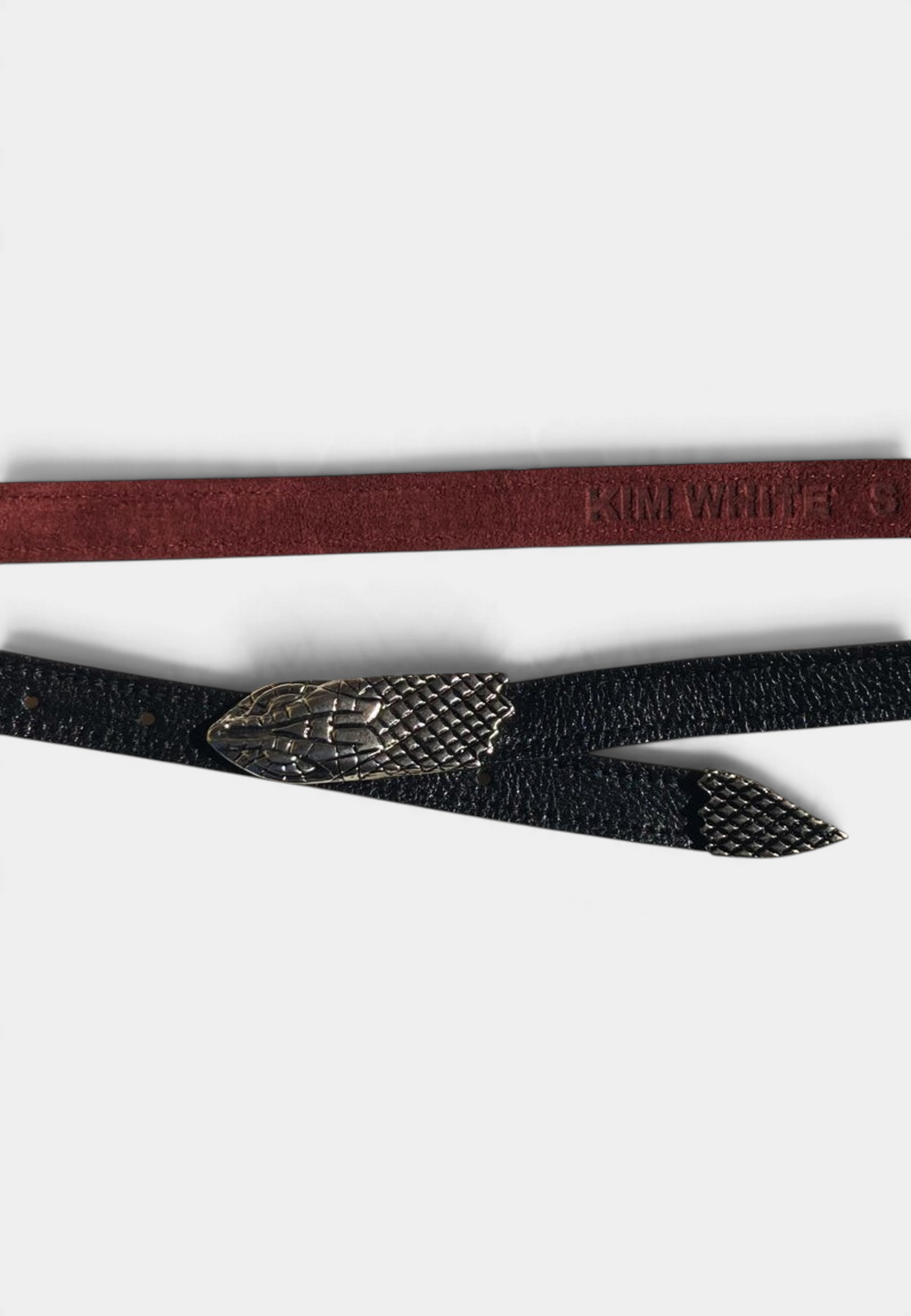 The Copper Shed skinny belt with antique nickel snake head and tail hardware on a textured black leather strap.