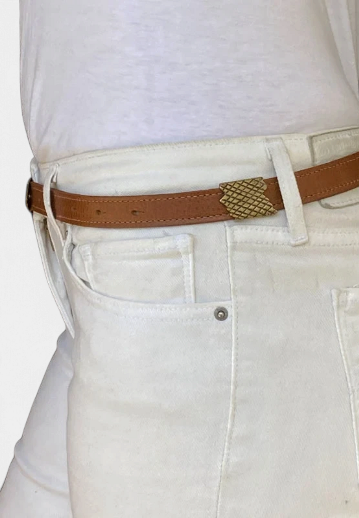 The Copper Shed skinny brown leather belt featuring a decorative antique nickel snake scale casting on white jeans.