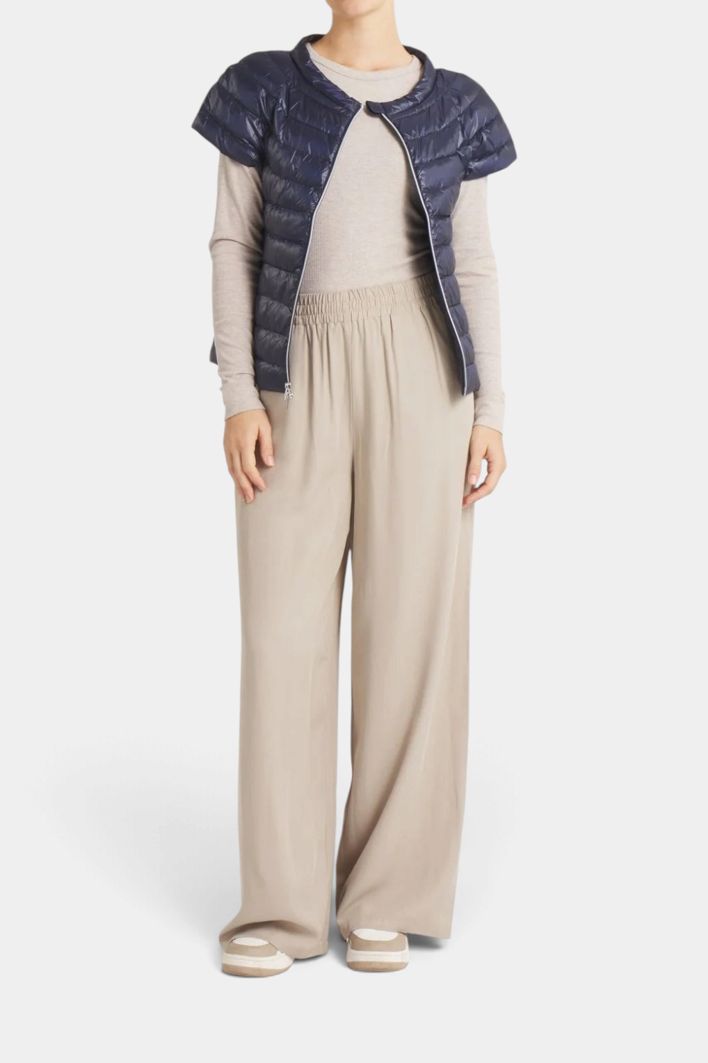 The Copper Shed St Ives navy blue ultra-light packable down vest with quarter sleeves worn over a beige outfit