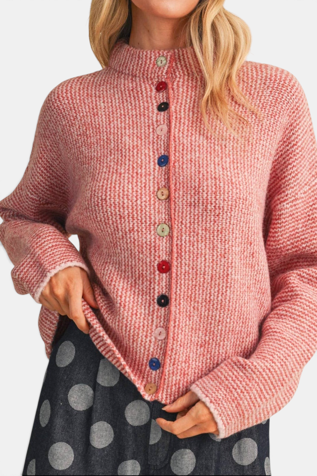 The Copper Shed striped mockneck cardigan in pink with a relaxed fit and multicolored buttons on a blonde model