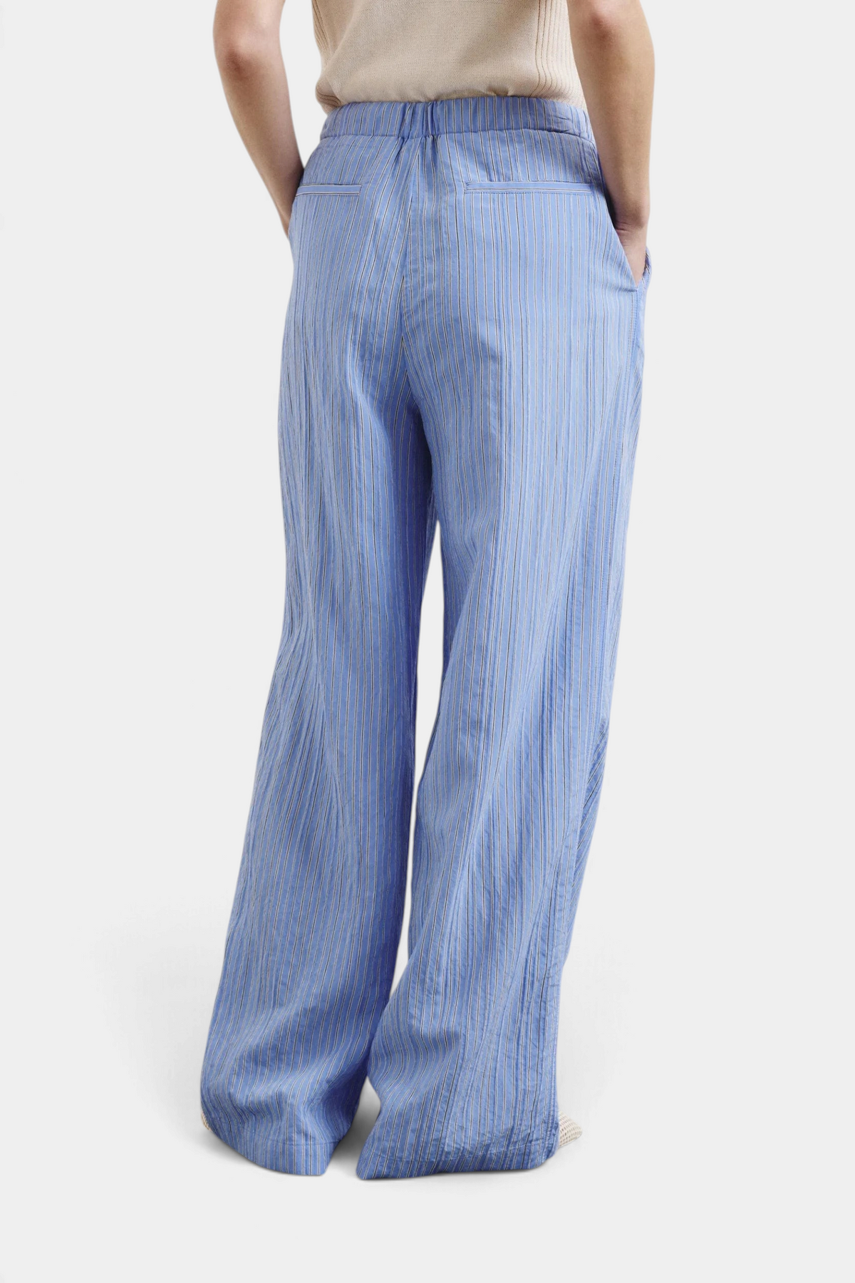 The Copper Shed striped blue technical viscose trousers with a relaxed pull-up fit, shown from the back view.