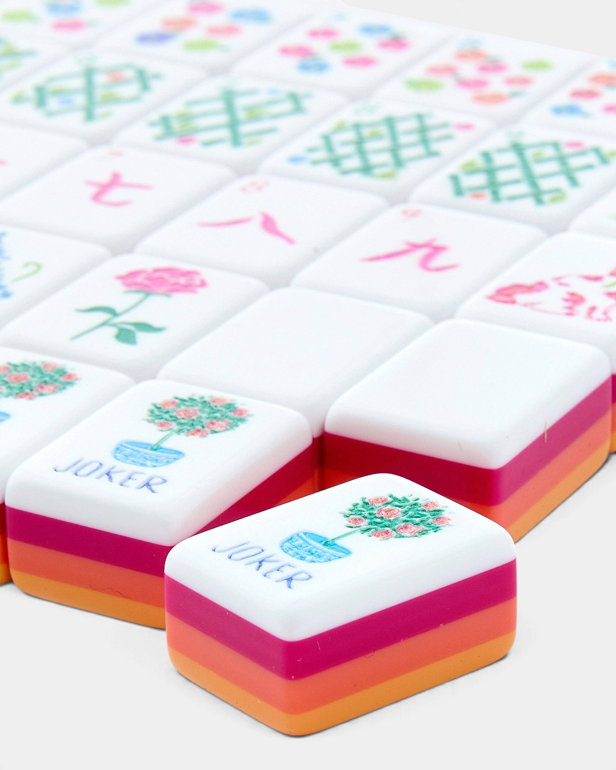 The Copper Shed Sunset mahjong tiles featuring vibrant coral, orange, and neon pink layered acrylic bases.