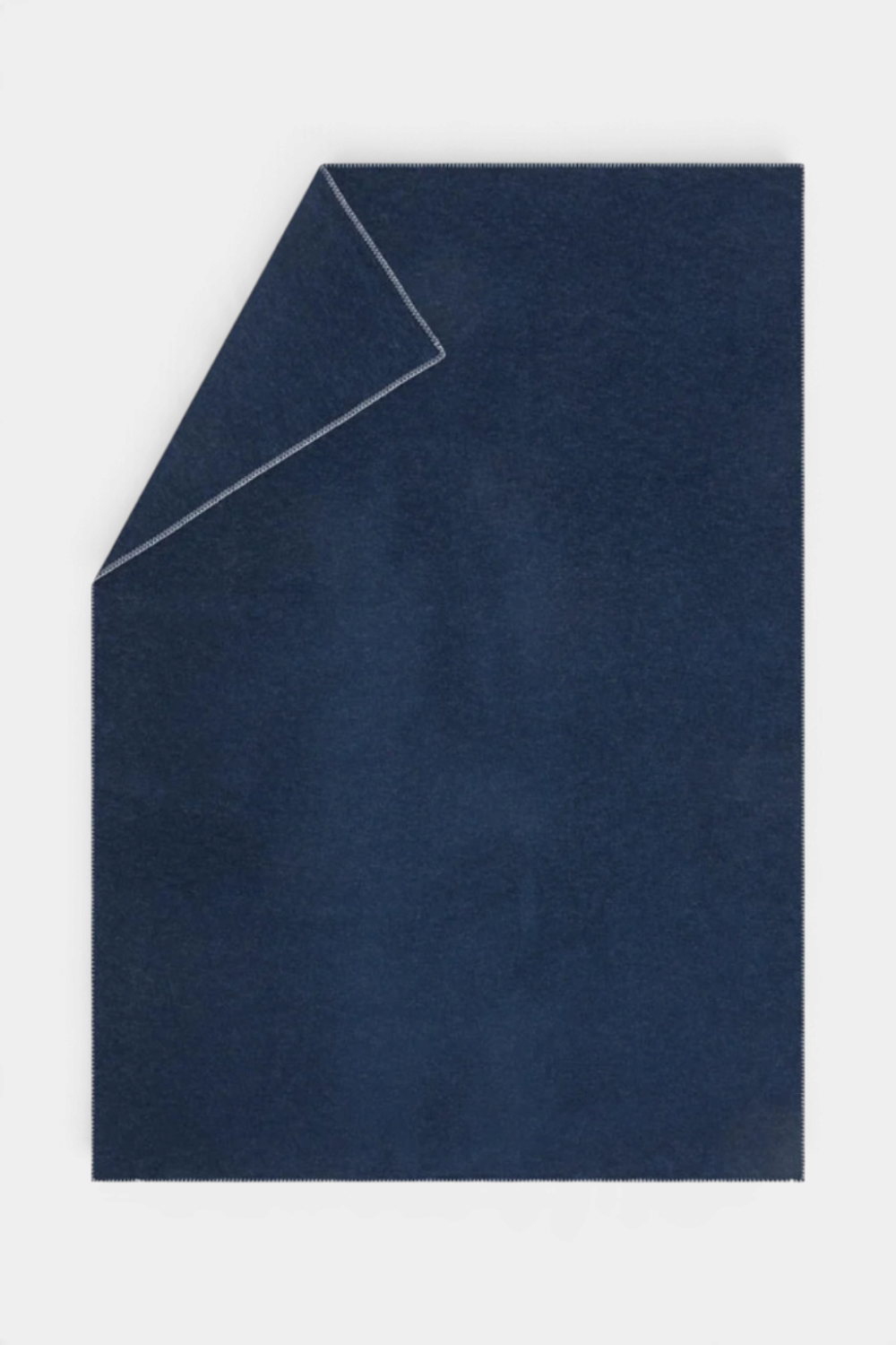 The Copper Shed SYLT navy blue recycled cotton blanket with decorative edge stitching for a cozy home accessory.