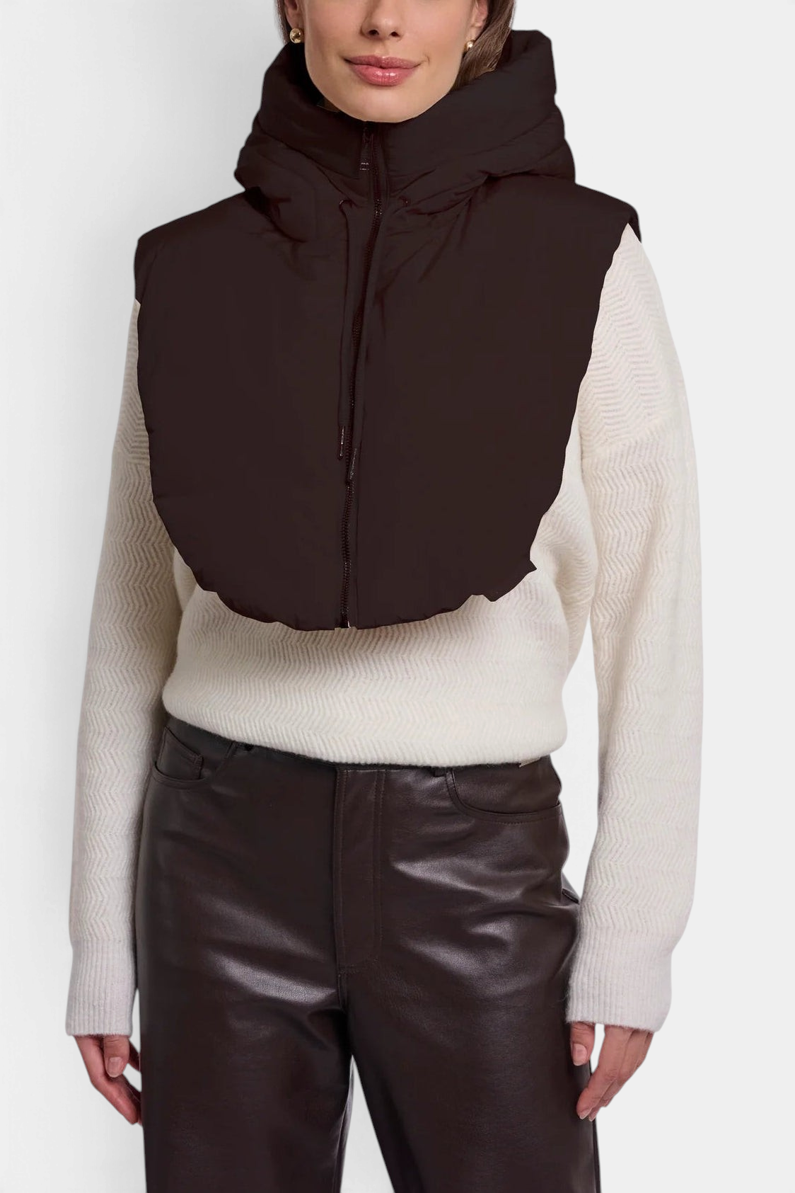 The Copper Shed Rino & Pelle Tabita padded bib in peated brown worn over a cream knit sweater.