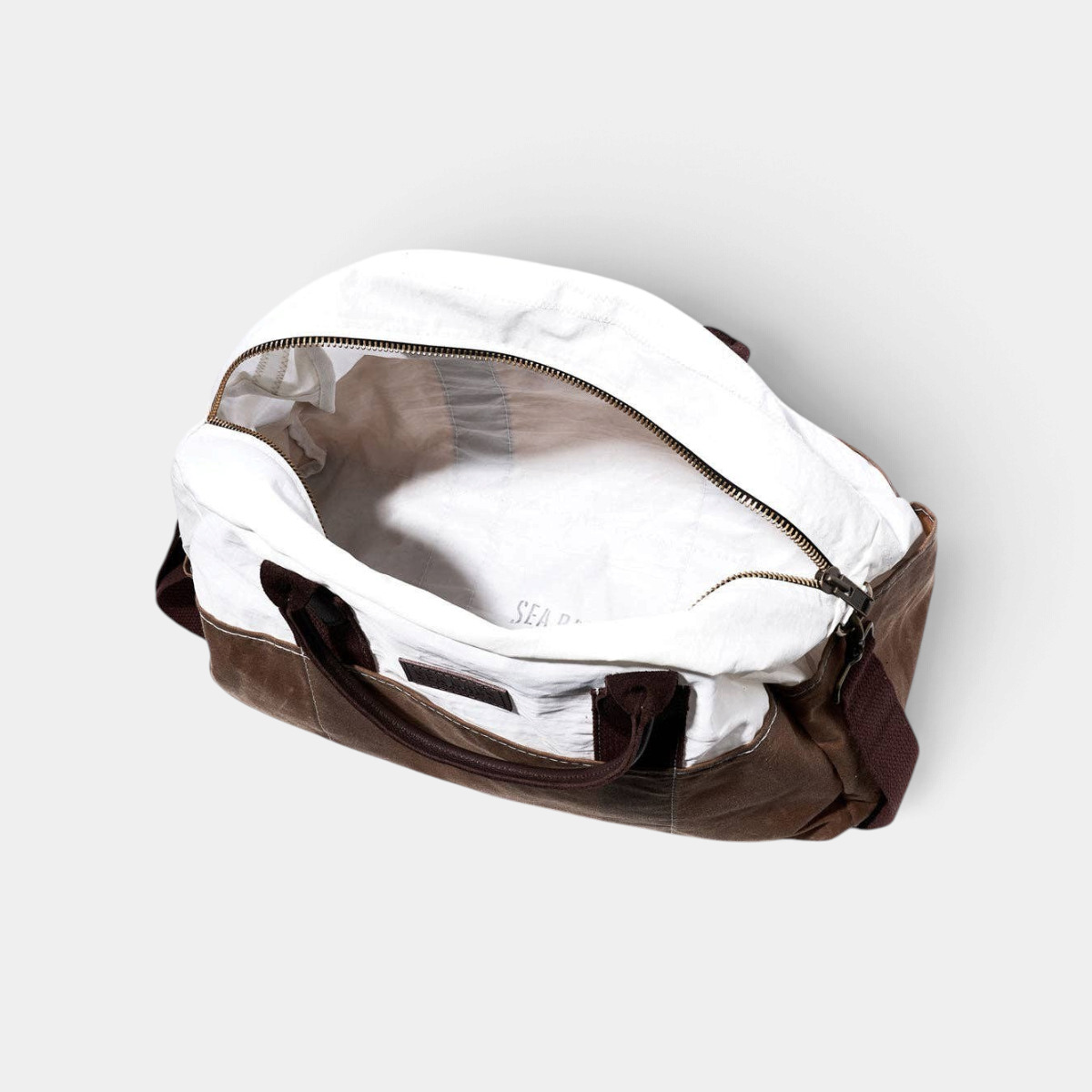 The Copper Shed Tan Chebeague Weekender bag in recycled white sail cloth and brown waxed canvas with leather handles.