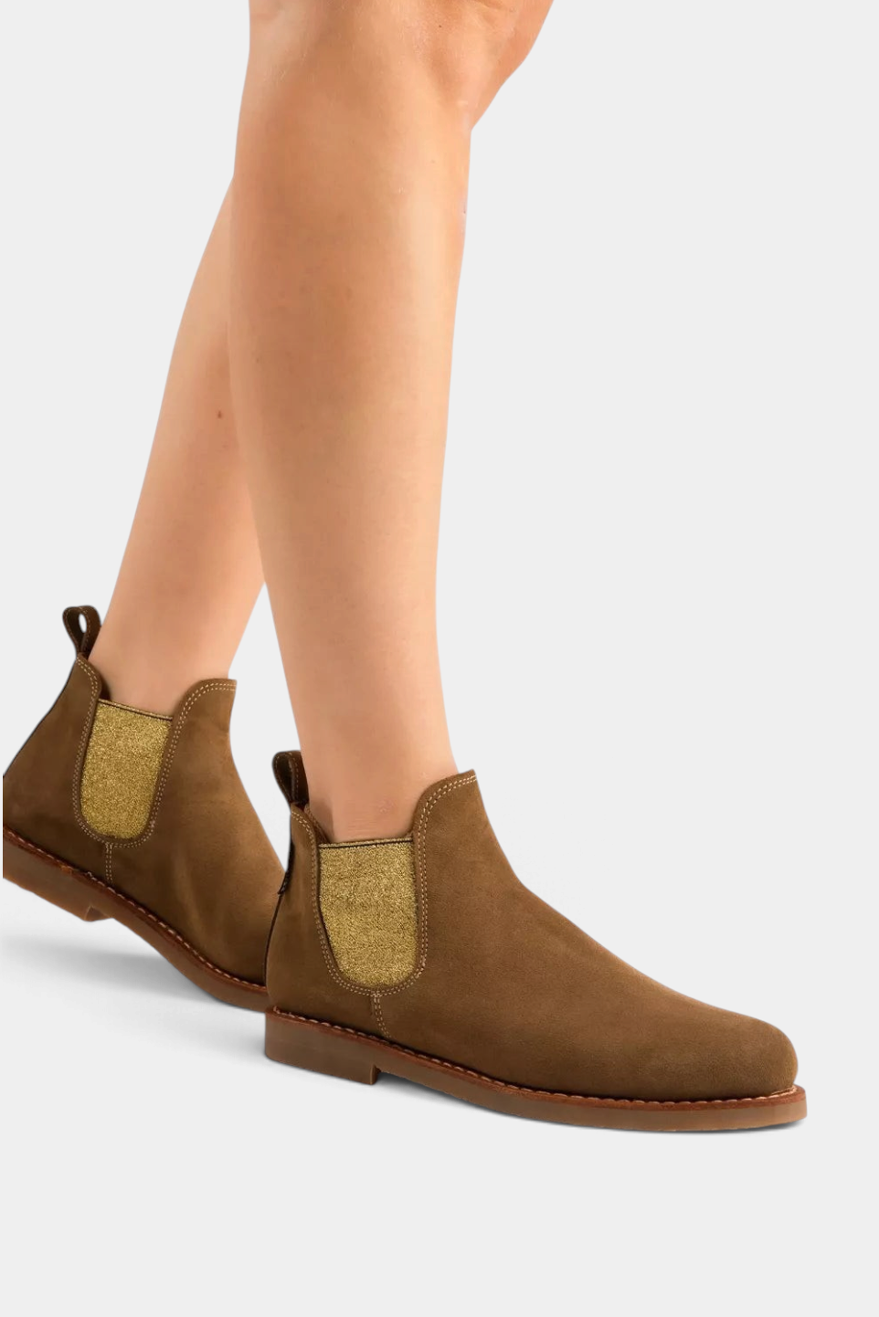 The Copper Shed tan suede Chelsea boots with gold elastic side panels and a durable crepe rubber sole on a model