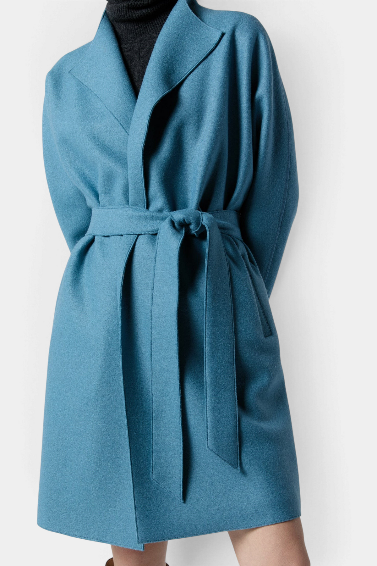 The Copper Shed Kimono Carina coat in teal blue boiled wool with a wrap-around tie waist and wide lapels.
