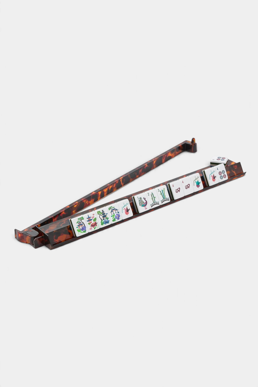 The Copper Shed tortoise shell acrylic mahjong rack and pusher set with game tiles on a white background