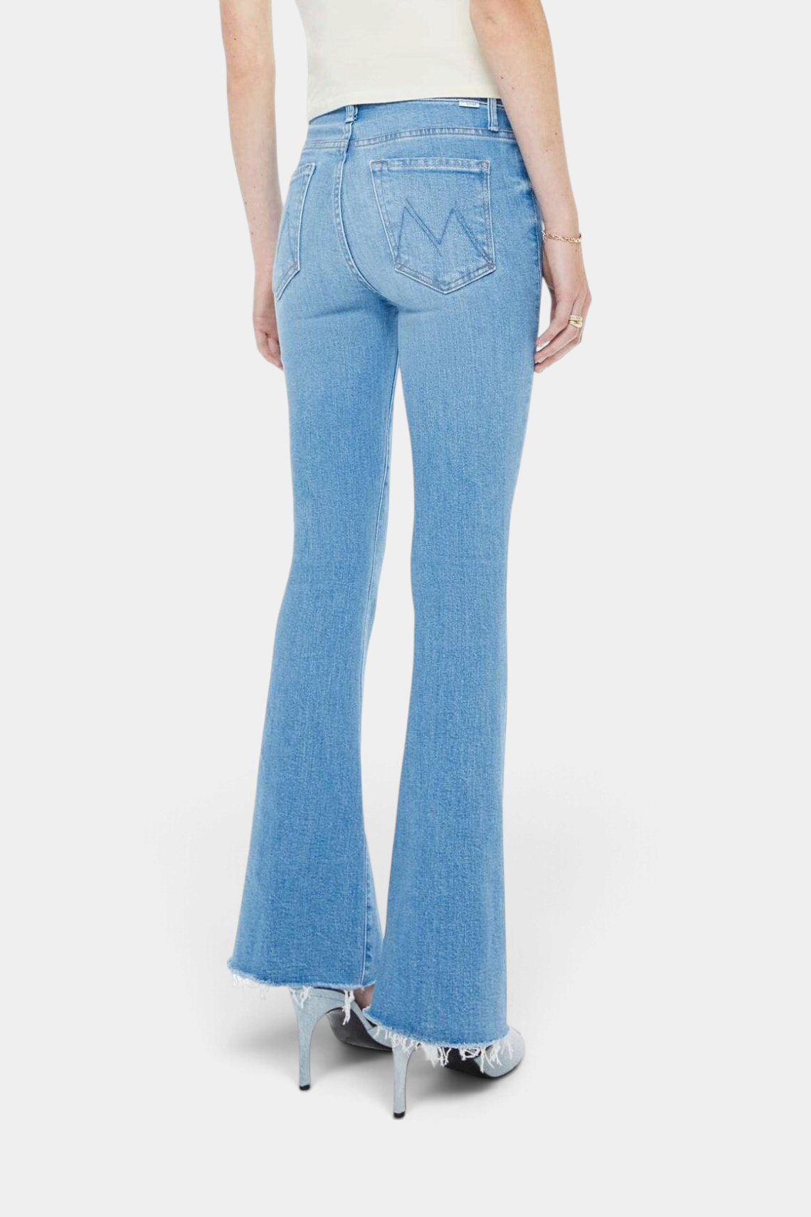 The Copper Shed light blue mid-rise flare jeans with a frayed hem, back view on a model