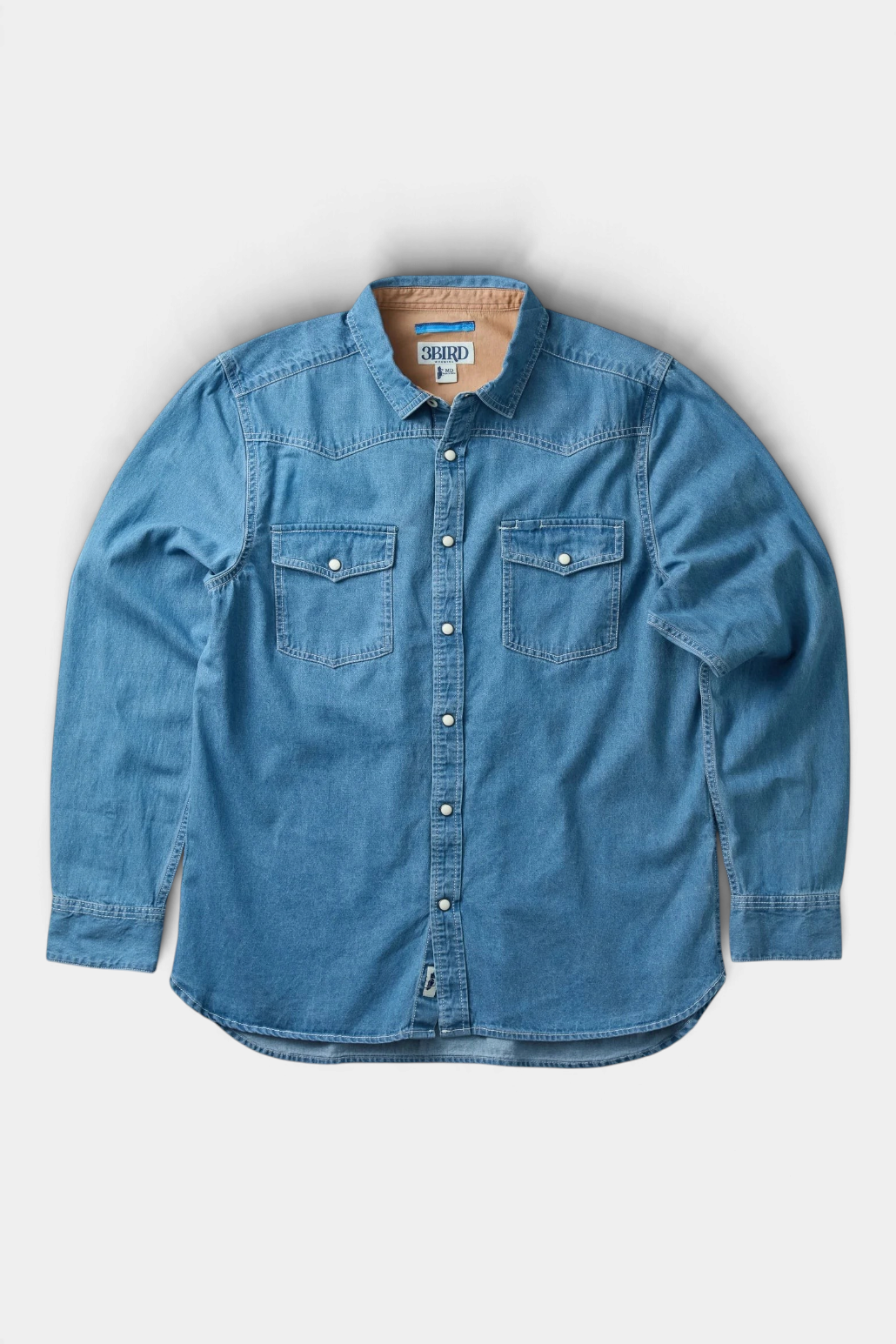 The Copper Shed Westside denim shirt in blue cotton with western pearl snaps and a chambray-lined collar.