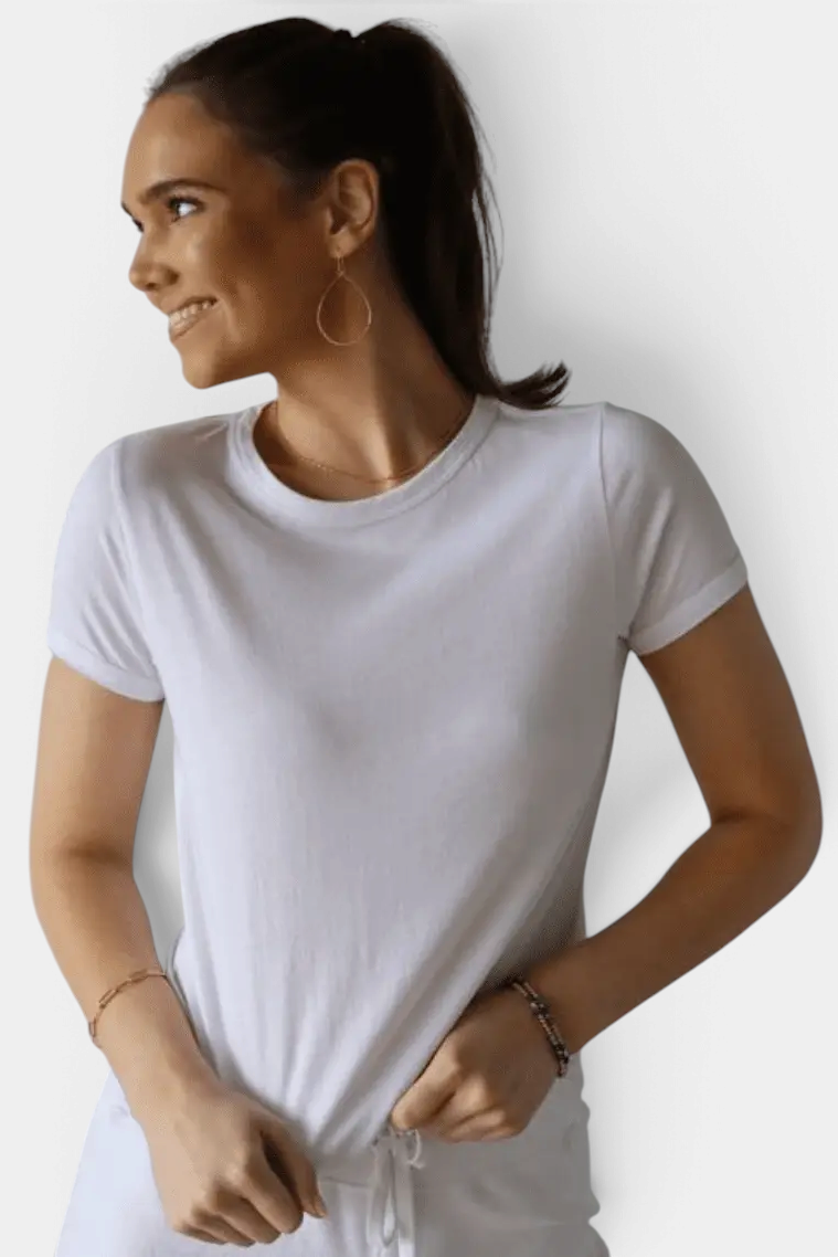 A woman wearing a soft white short sleeve Polished Tee by The Copper Shed, featuring a smooth cotton modal blend.