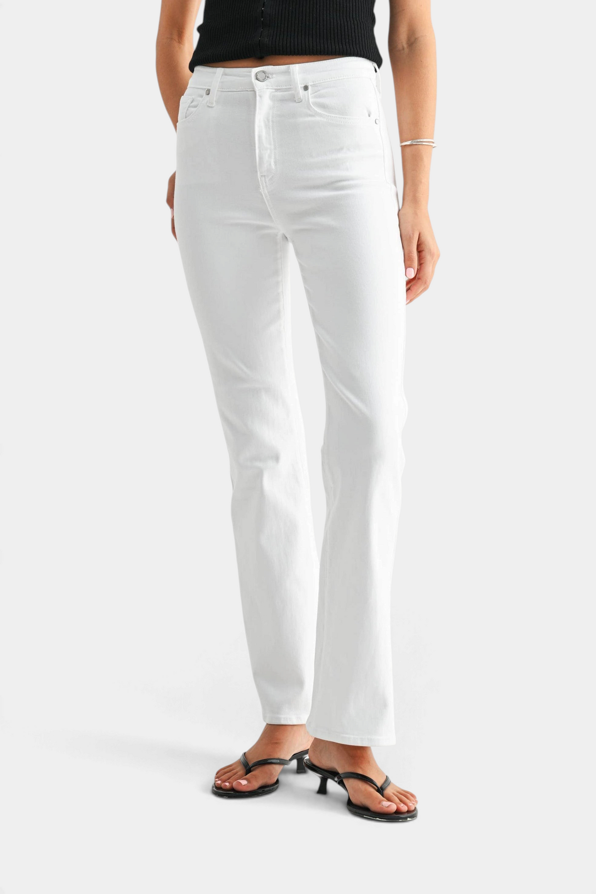 The Copper Shed high-rise optic white denim jeans with a relaxed fit and flared hem worn by a model