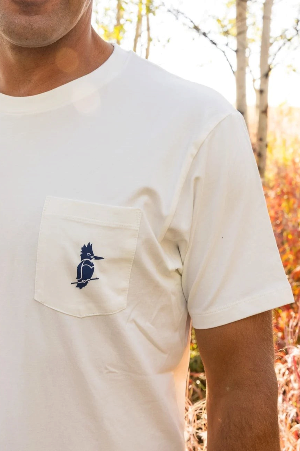 The Copper Shed Petey Pocket Tee in white organic cotton with a blue bird logo on the chest pocket