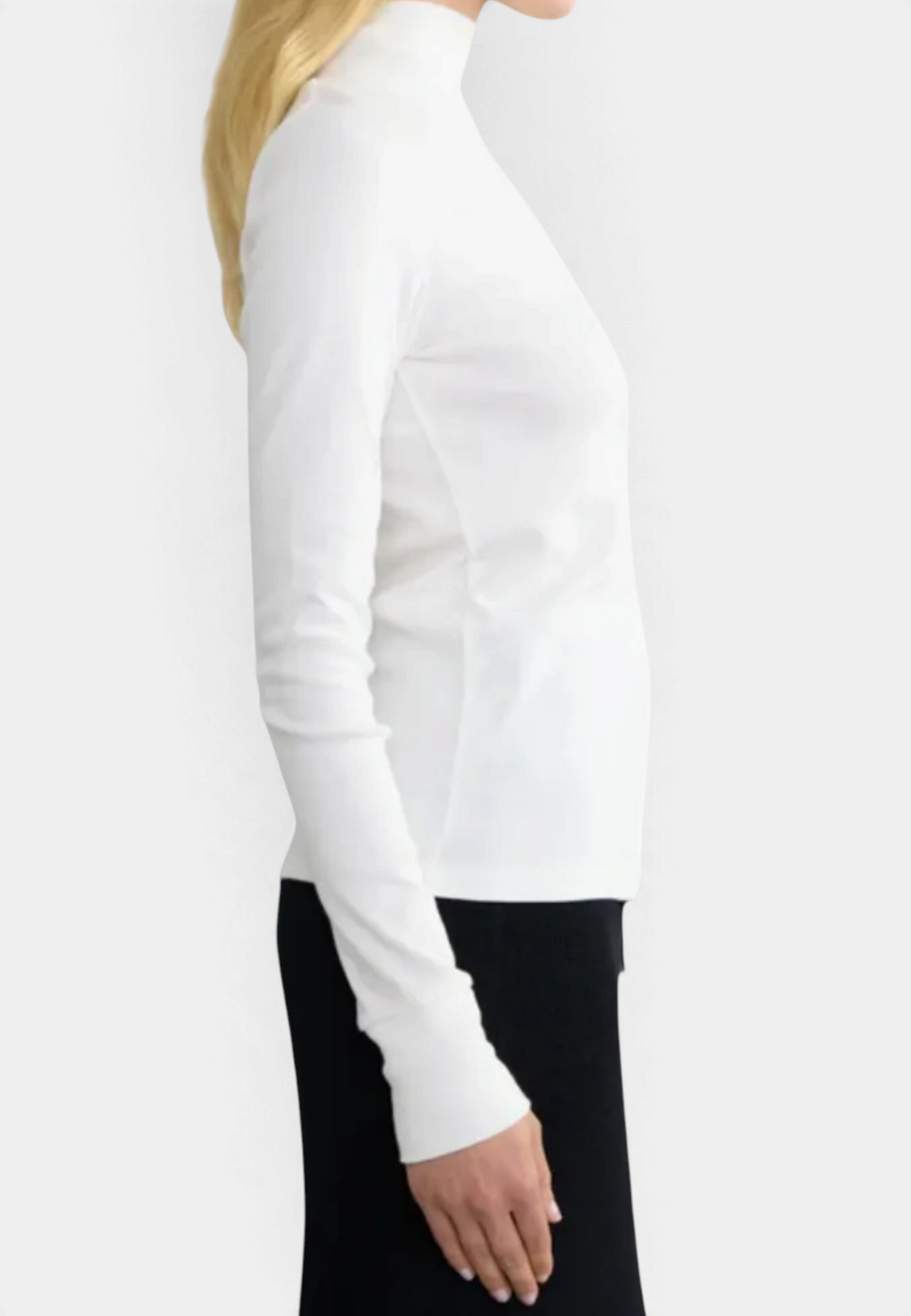The Copper Shed white long sleeve ribbed organic cotton turtleneck worn by a woman, side profile view.