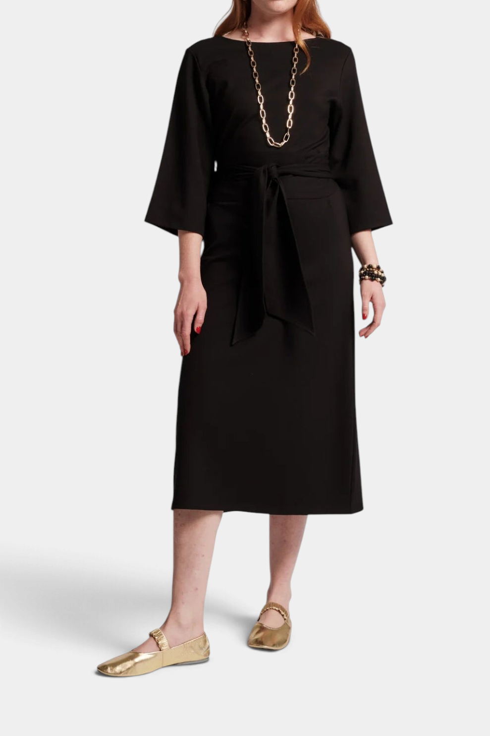 The Copper Shed Whitney wrap midi dress in black with a crew neckline, cinched waist tie, and three-quarter sleeves.