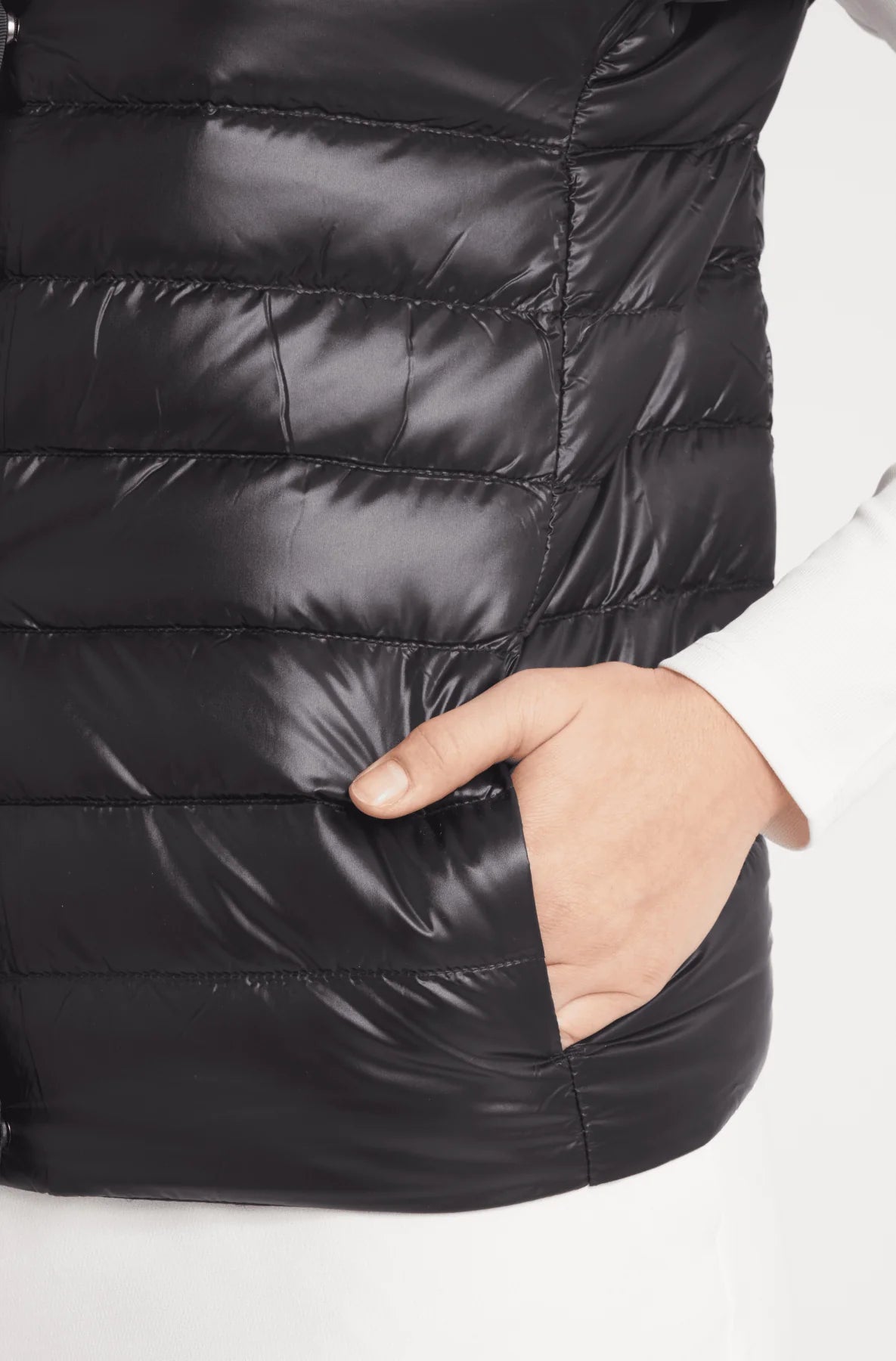 Close-up of a person wearing a black puffer jacket on a white background