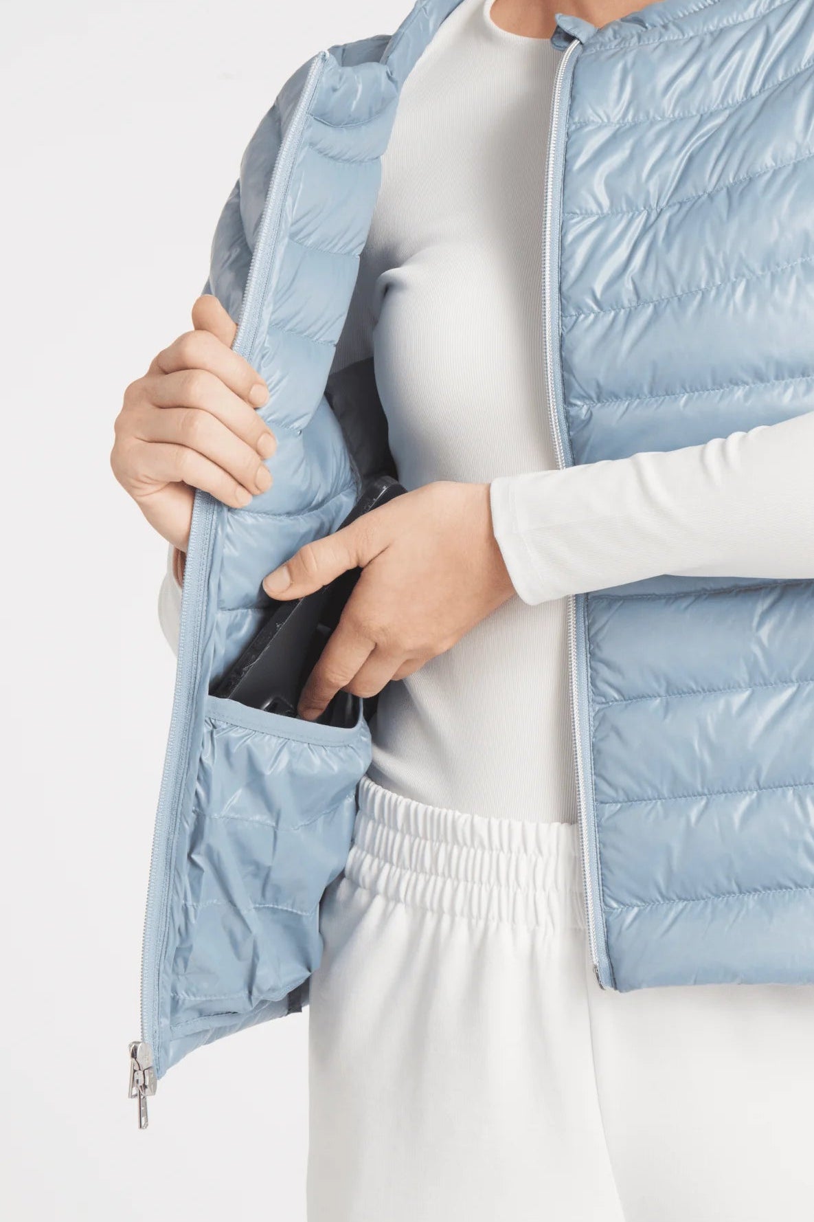 Light blue puffer jacket worn by a person on a light gray background