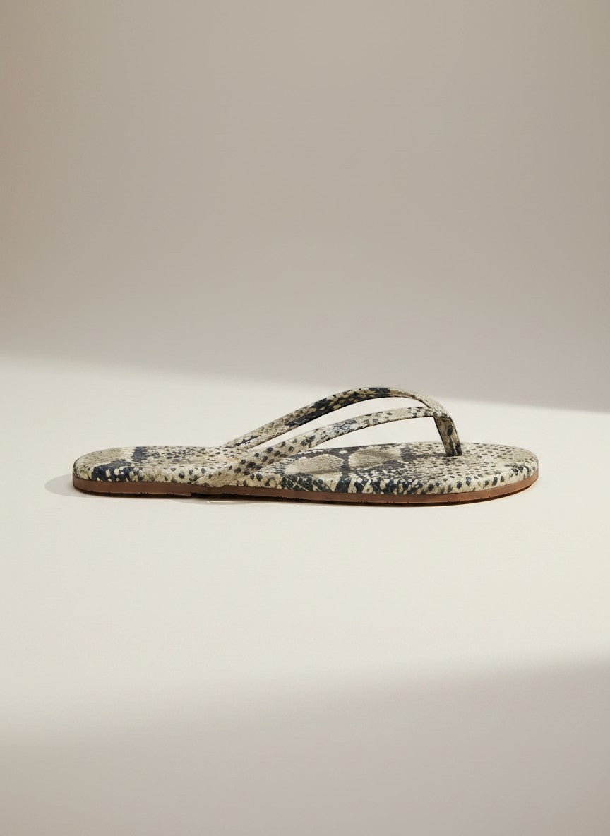 The Copper Shed neutral snake print flip flops with thong strap and flat sole.