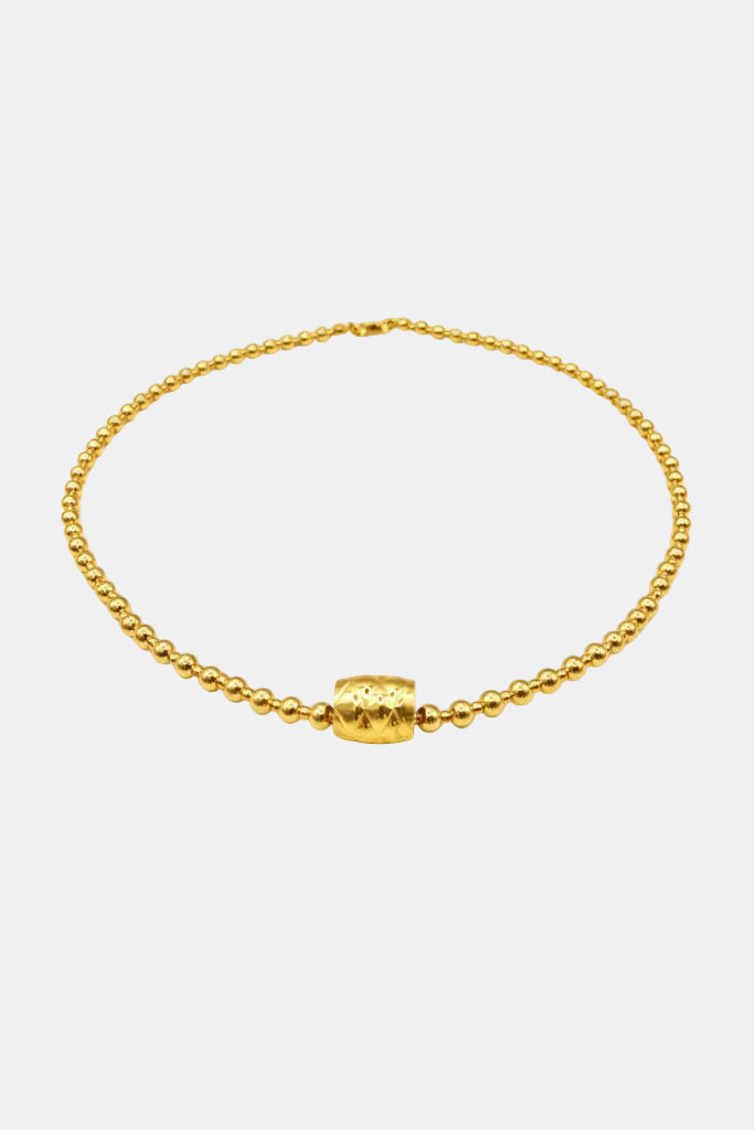 Gold beaded necklace on a white background