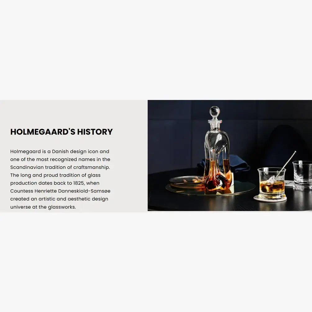 Holmegaard glass decanter and glasses on a dark surface with text about the brand's history.