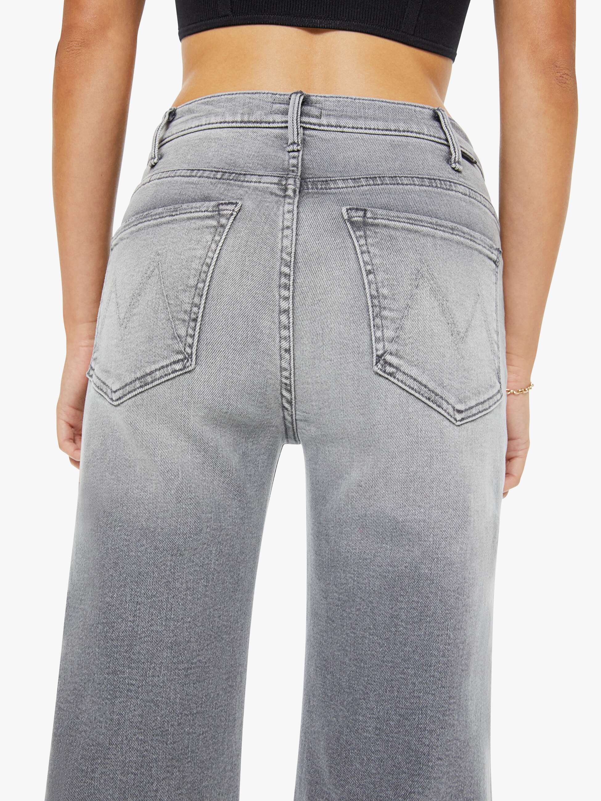Gray jeans worn by a person on a white background