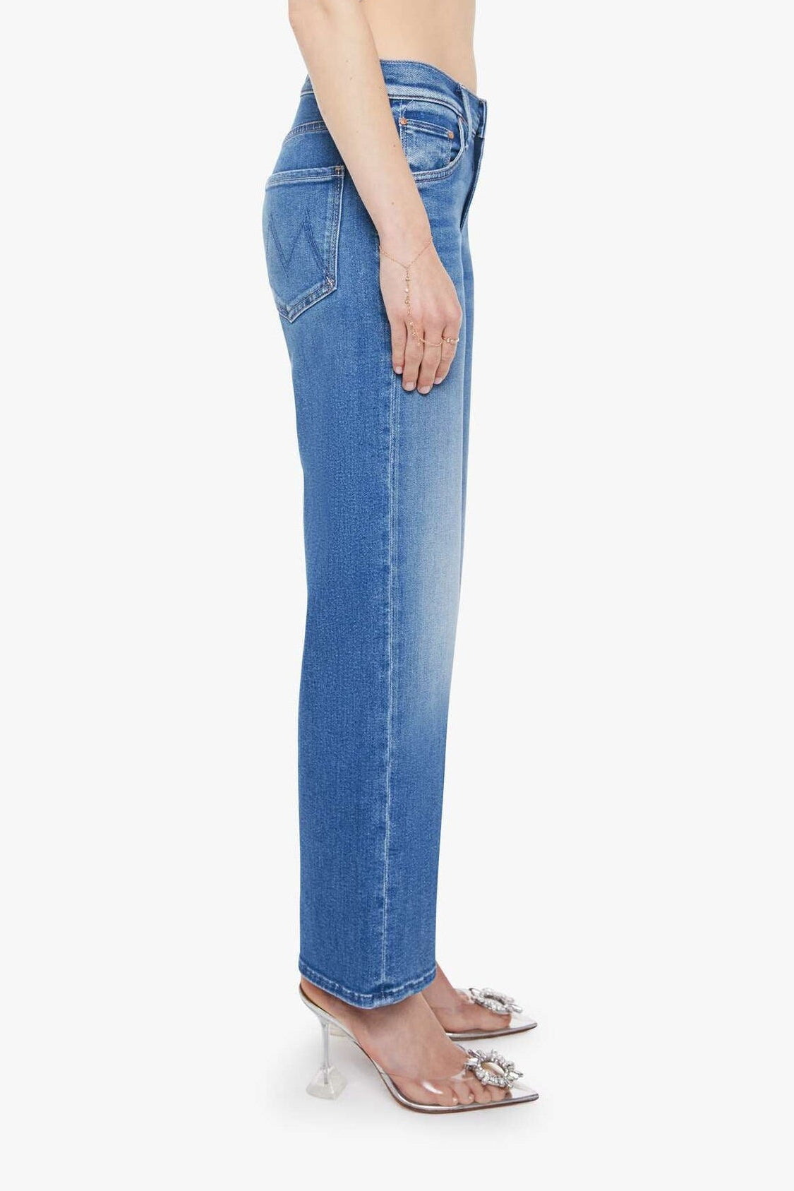 Woman wearing blue jeans and a white top on a white background