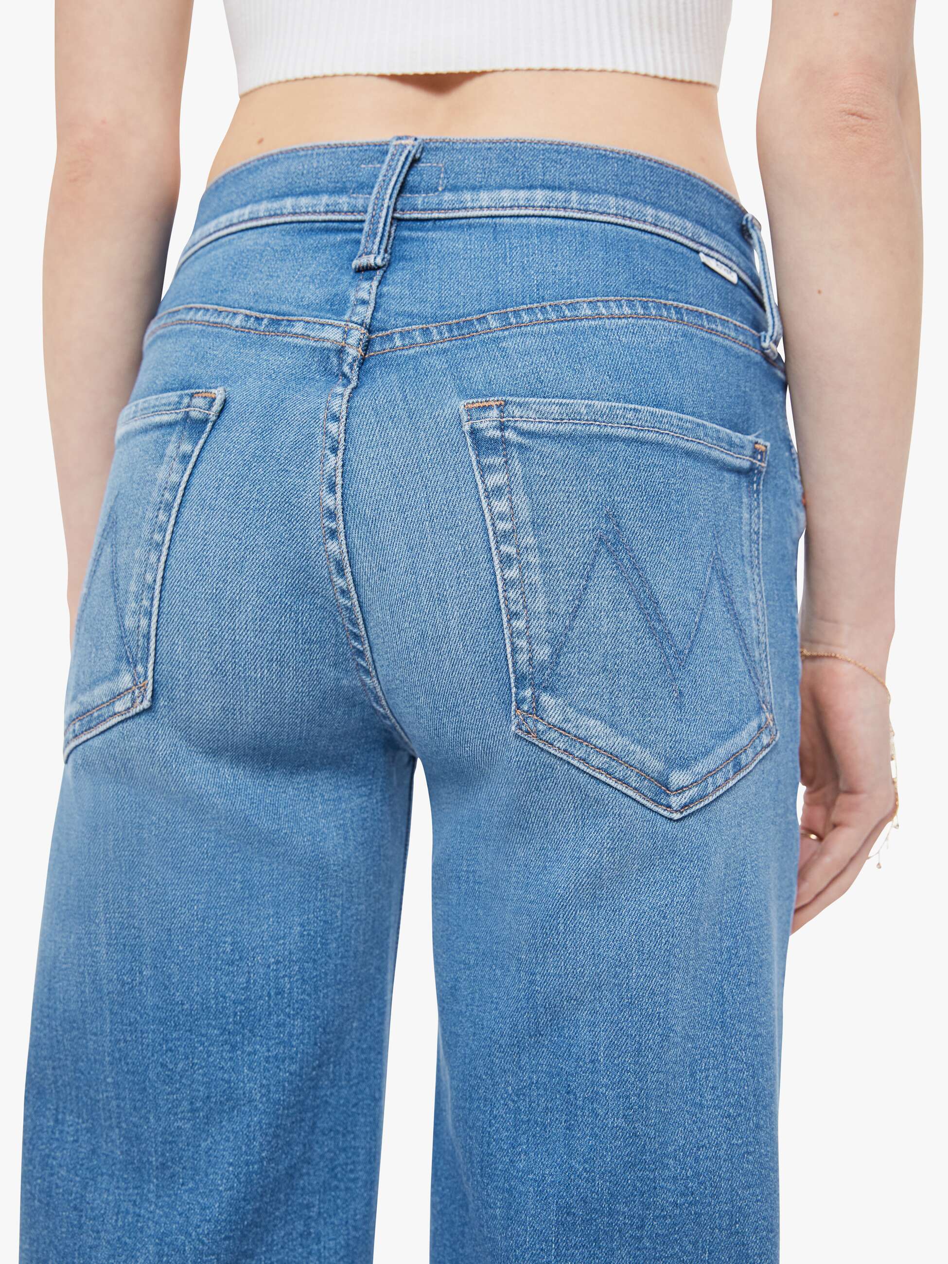 Blue jeans worn by a person on a white background
