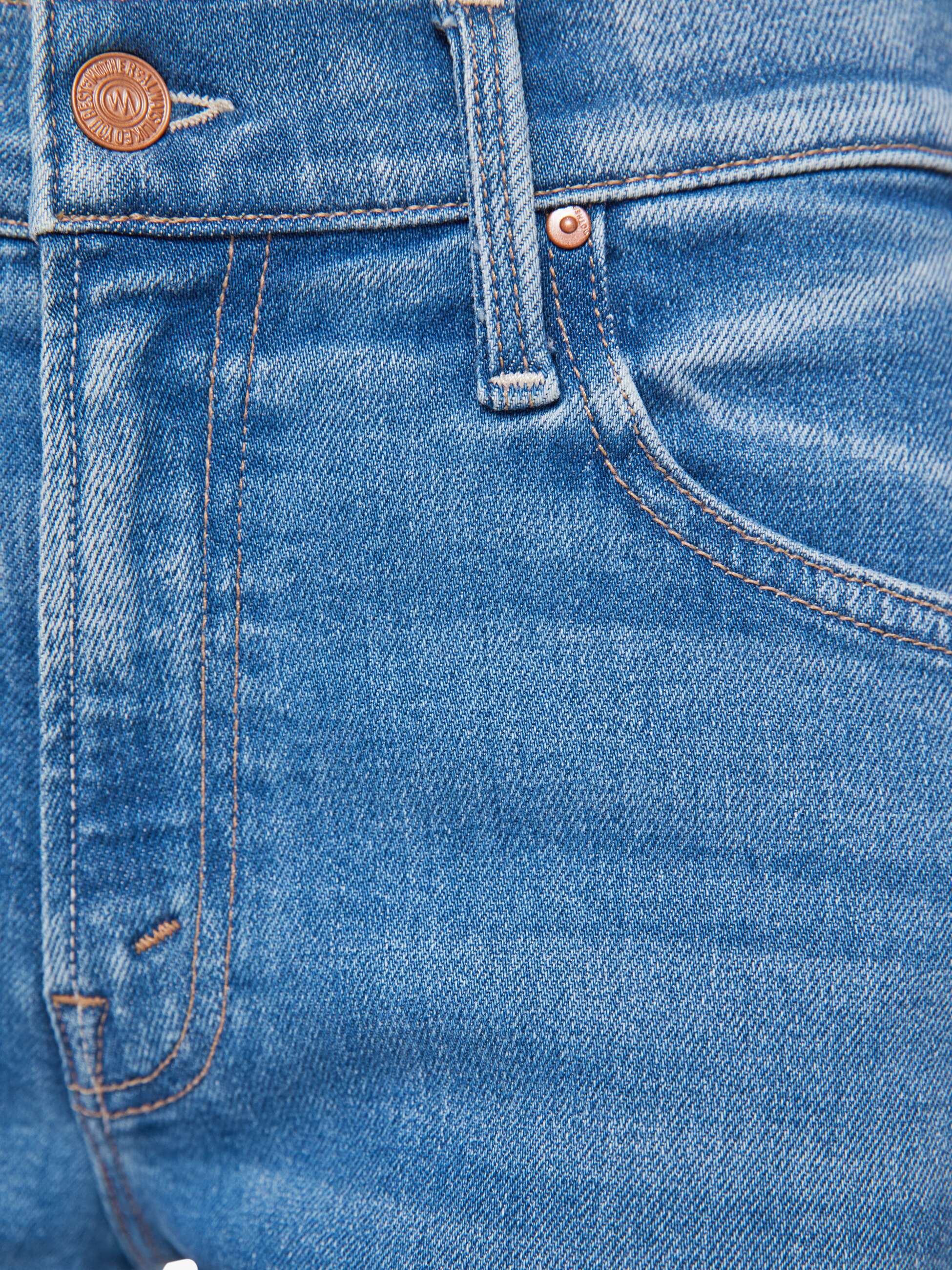 Close-up of blue denim fabric with stitching details