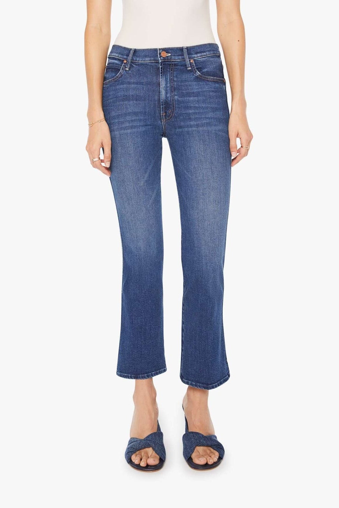 Woman wearing blue jeans and a white top on a white background