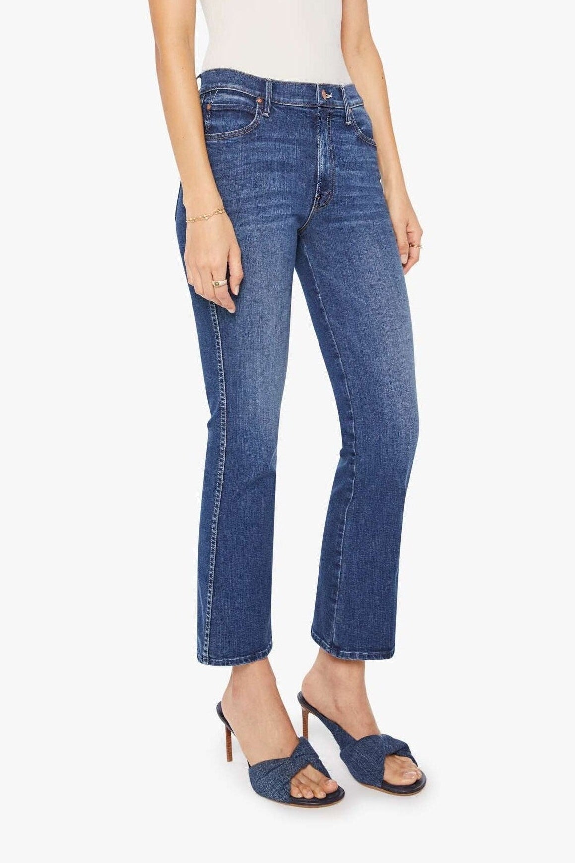 Woman wearing blue jeans and a white top on a white background