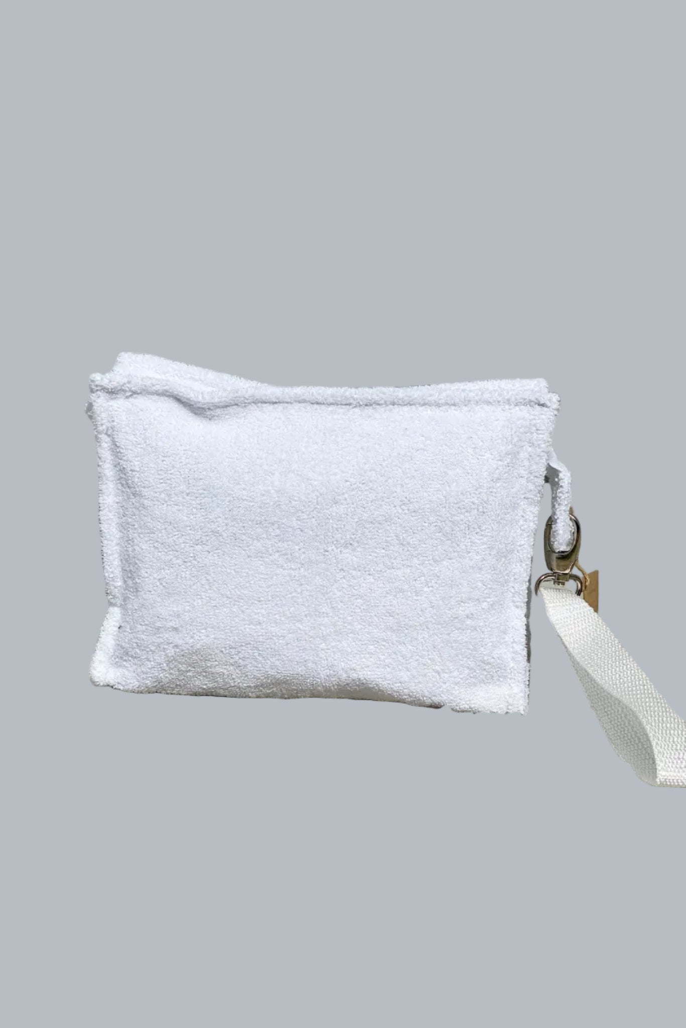 White pouch with a strap on a stone surface