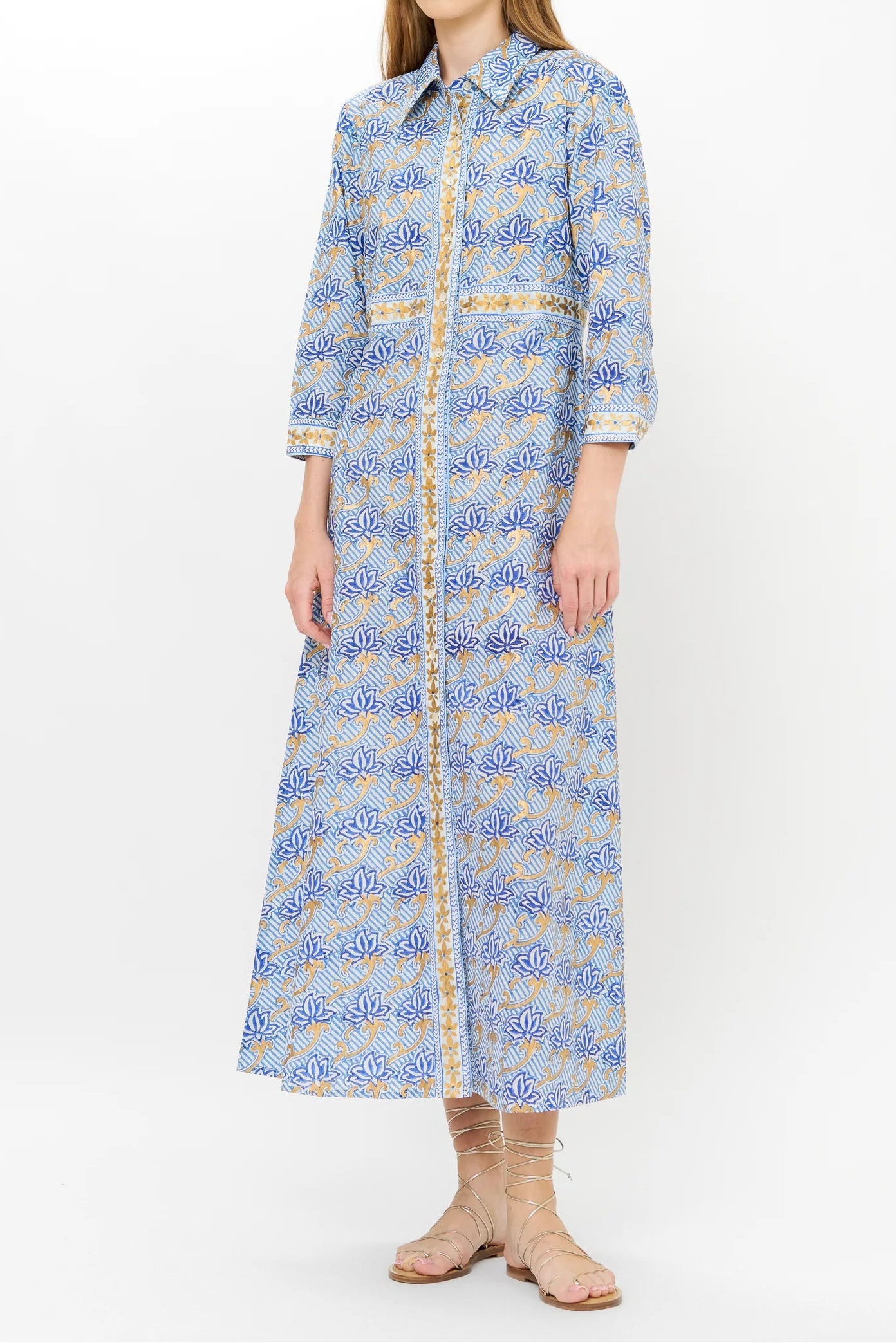 Woman wearing a long blue floral dress on a white background
