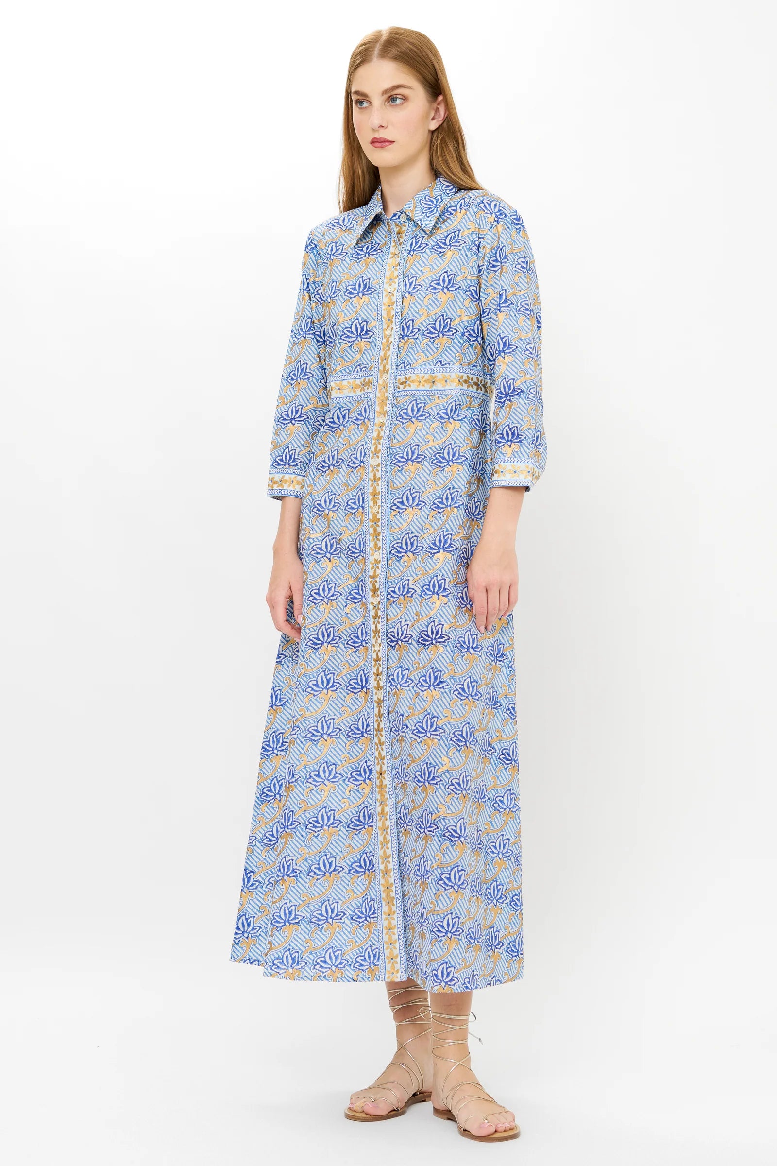Woman wearing a long blue floral dress on a white background