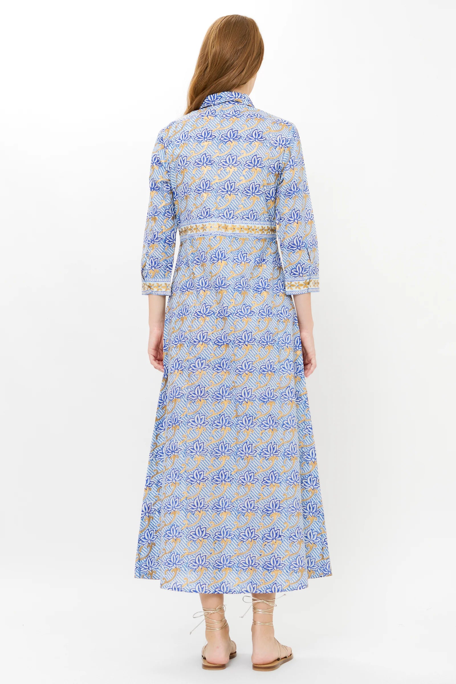 Woman wearing a long, light blue dress with a subtle pattern on a white background