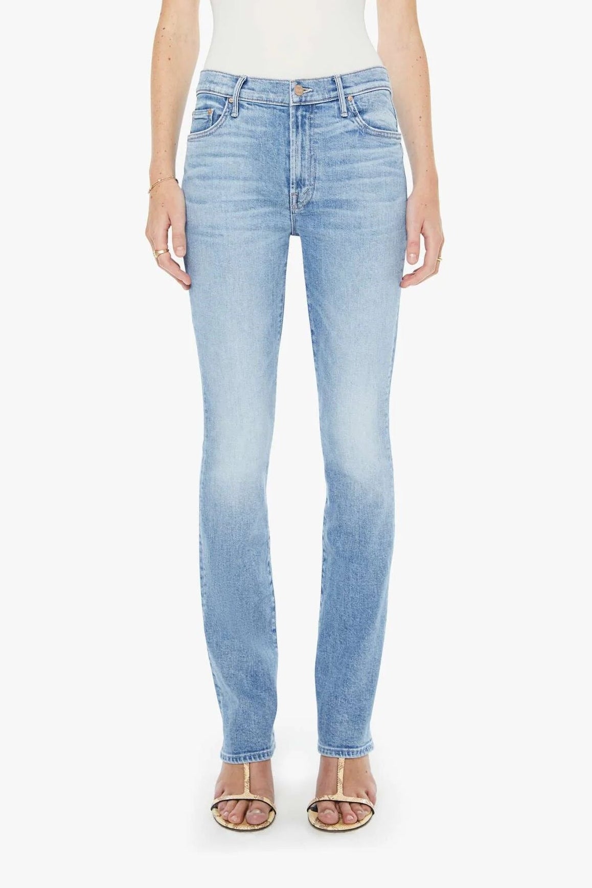 Woman wearing light blue jeans and a white top on a white background