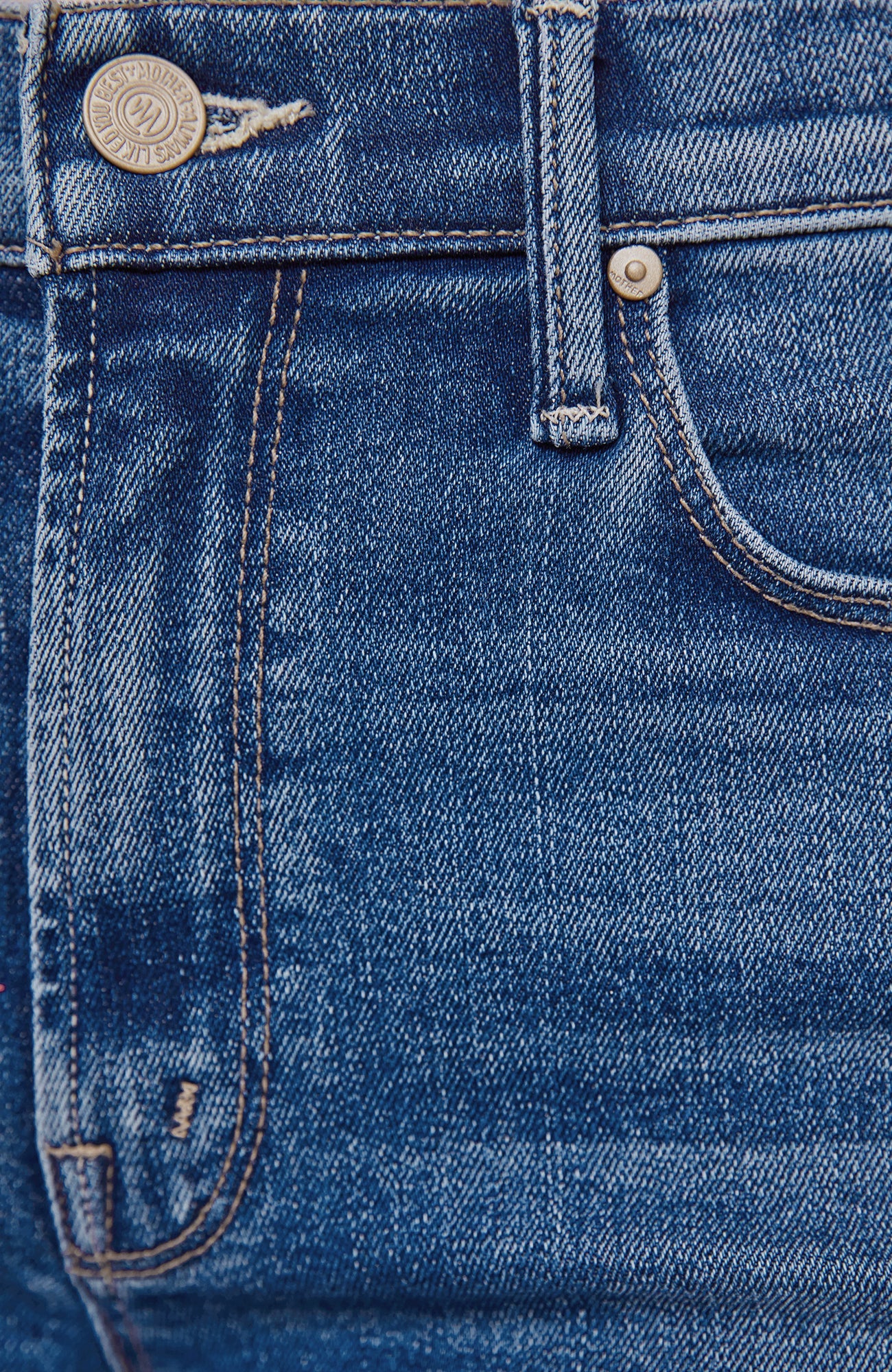 Close-up detail of blue denim jeans showing the waistband, button, belt loop, front pocket, and stitching.