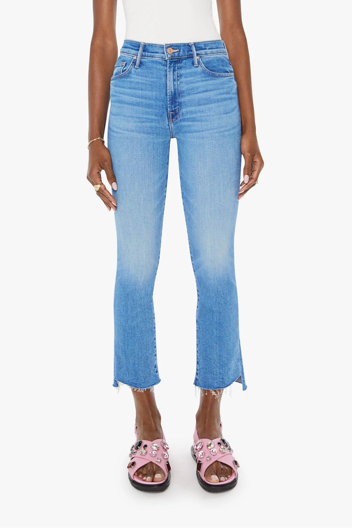 Woman wearing a white top and blue jeans on a white background