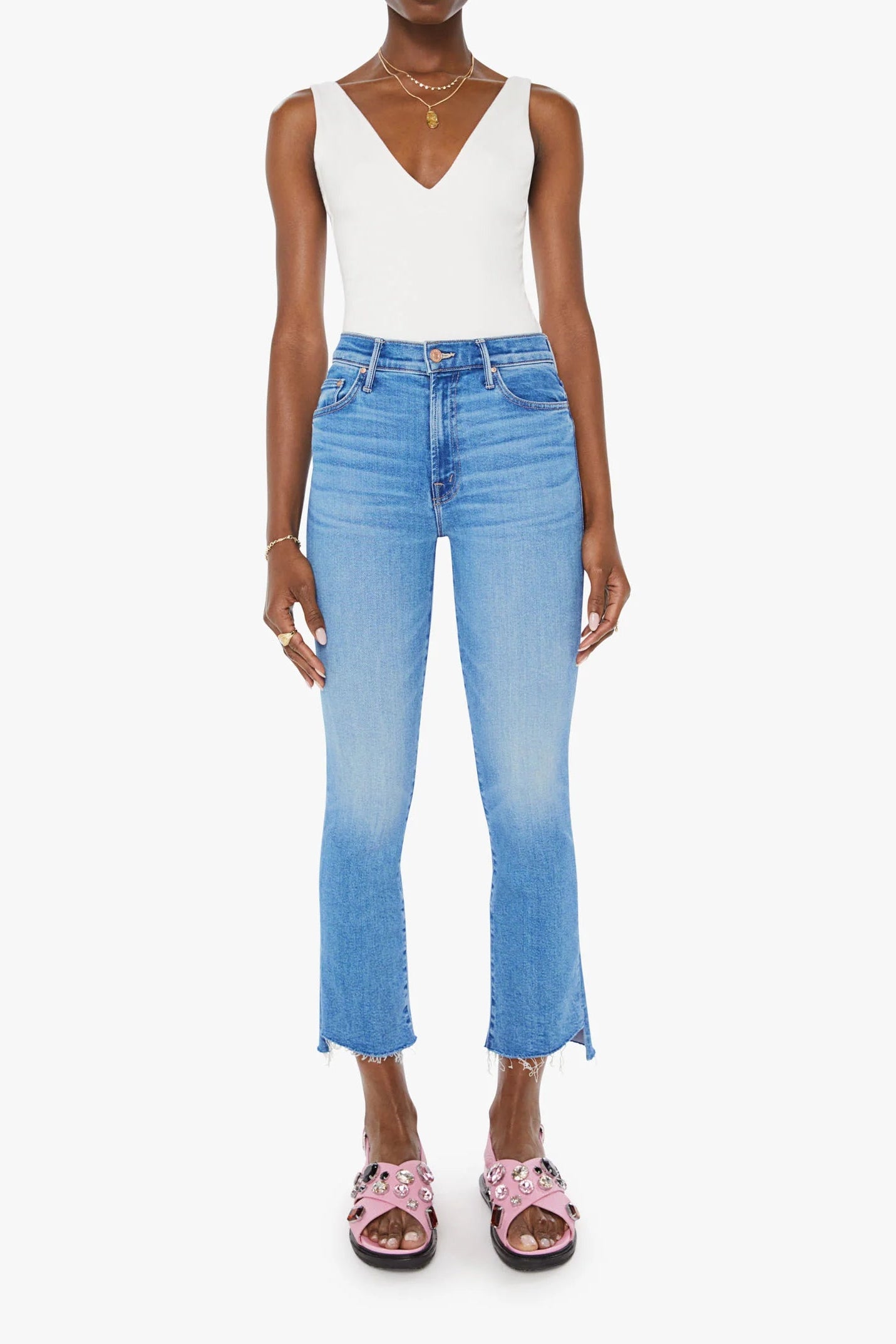 Woman wearing a white top and blue jeans on a white background