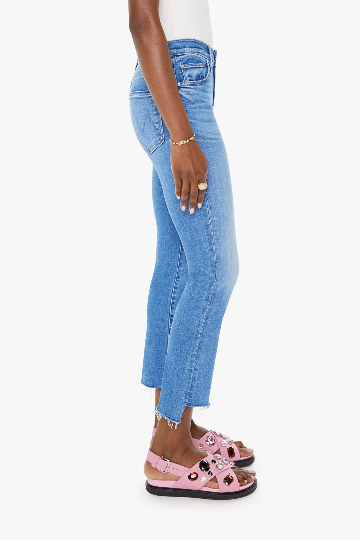 Woman wearing blue jeans and a white top on a white background