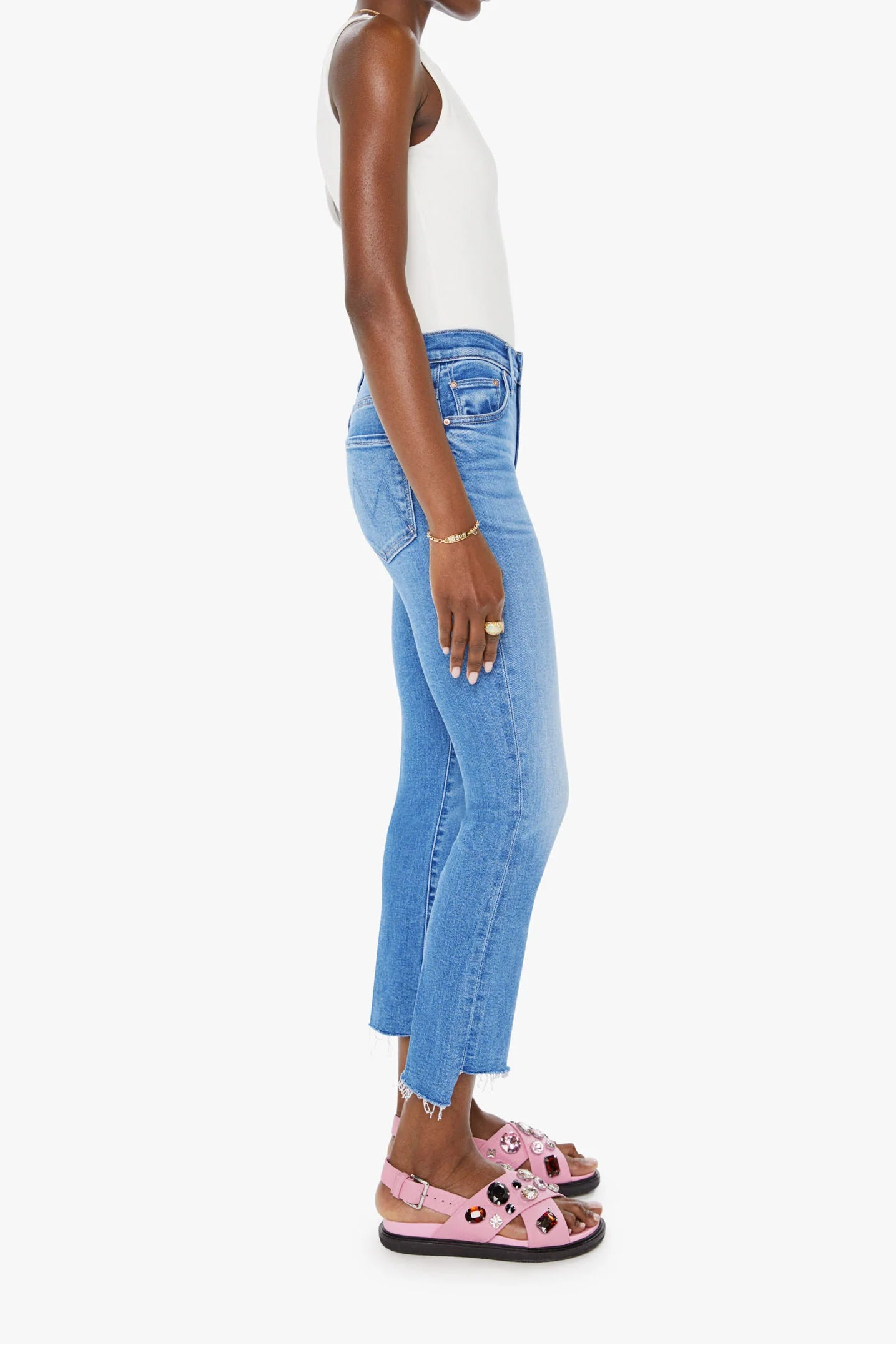 Woman wearing blue jeans and a white top on a white background