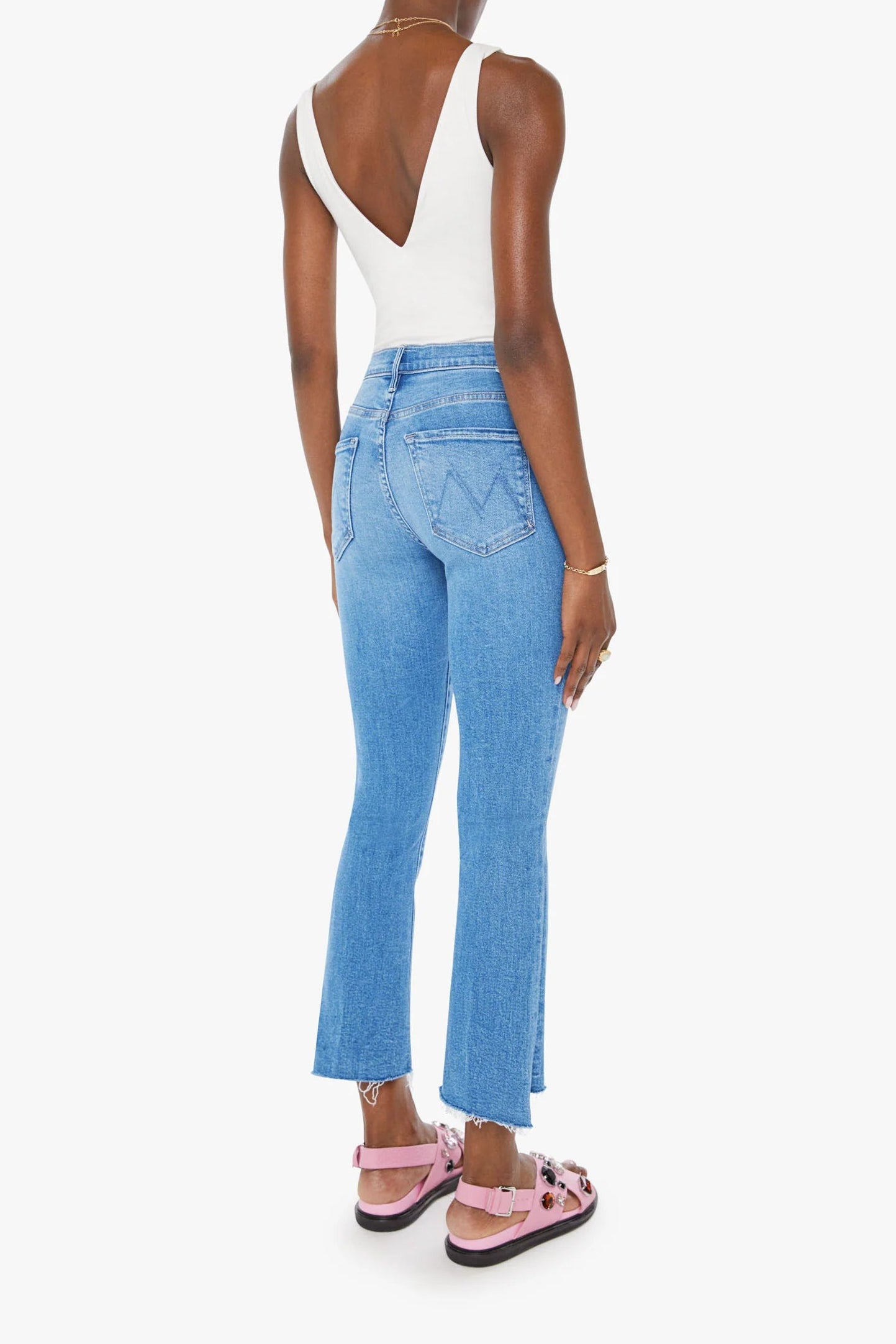 Person wearing a white top and blue jeans on a white background