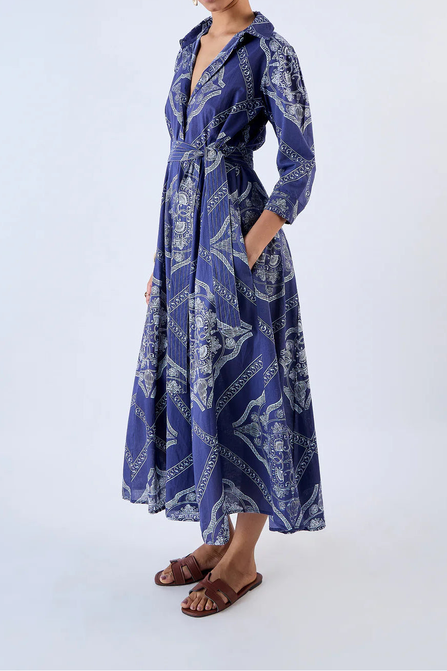 Woman wearing a blue patterned dress on a white background