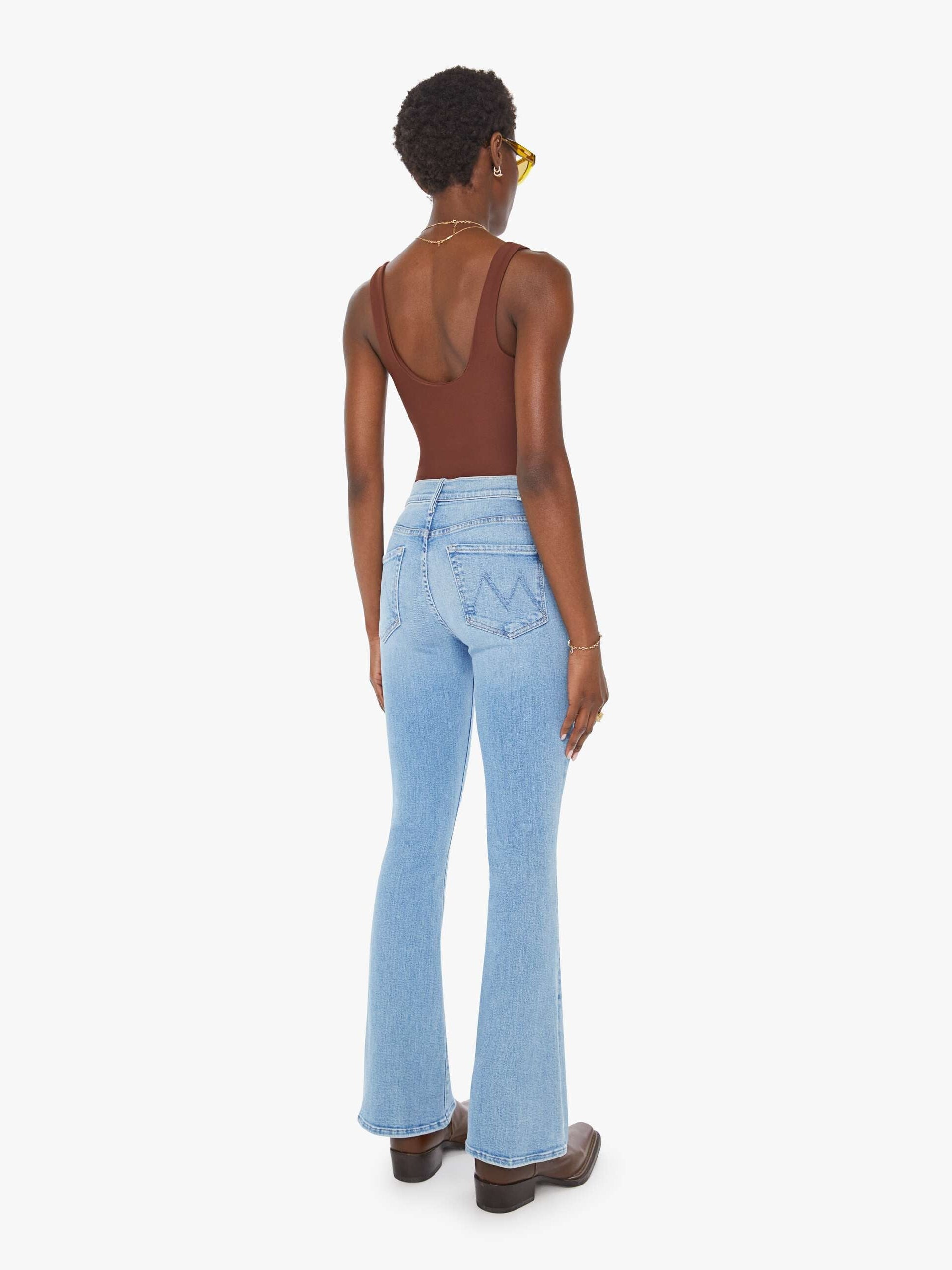 Person wearing light blue jeans on a white background