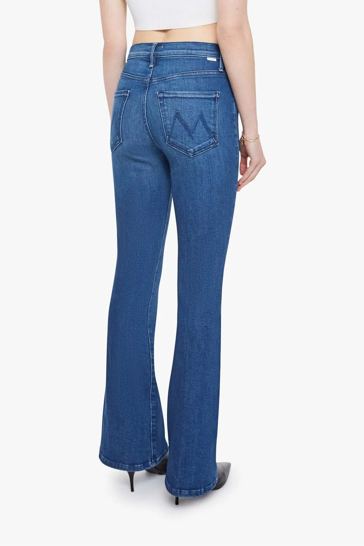 Woman wearing blue jeans and a white top on a white background